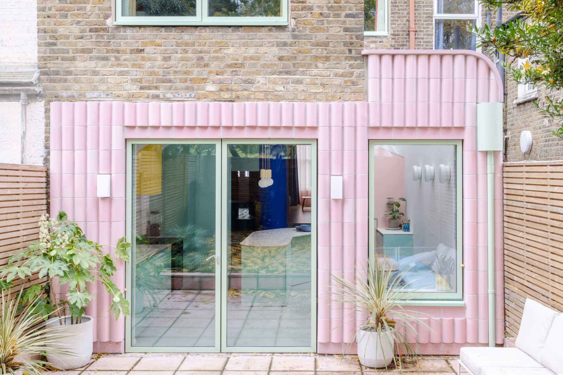 A contemporary addition full of colour and clad in handmade glazed tiles in pastel pink.