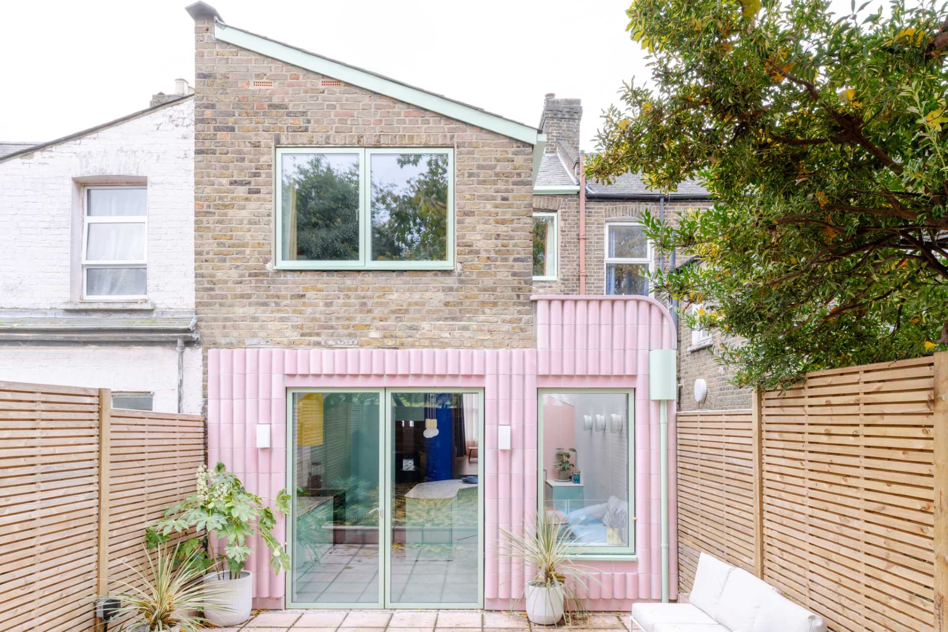 A contemporary addition full of colour and clad in handmade glazed tiles in pastel pink.