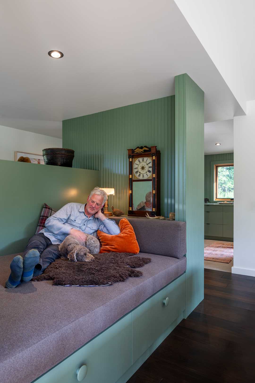 A small secluded home with a built-in day bed nook and bookshelves.