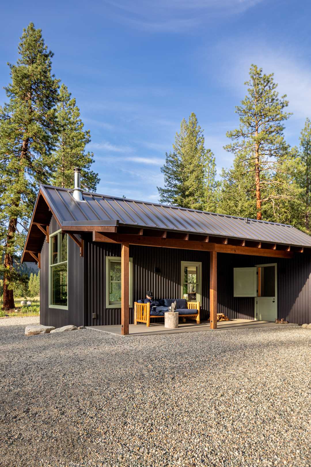 Metal roofing, siding, and a gravel skirt were chosen for this small house to reduce wildfire risk, and native plantings attract and support local birds and wildlife.