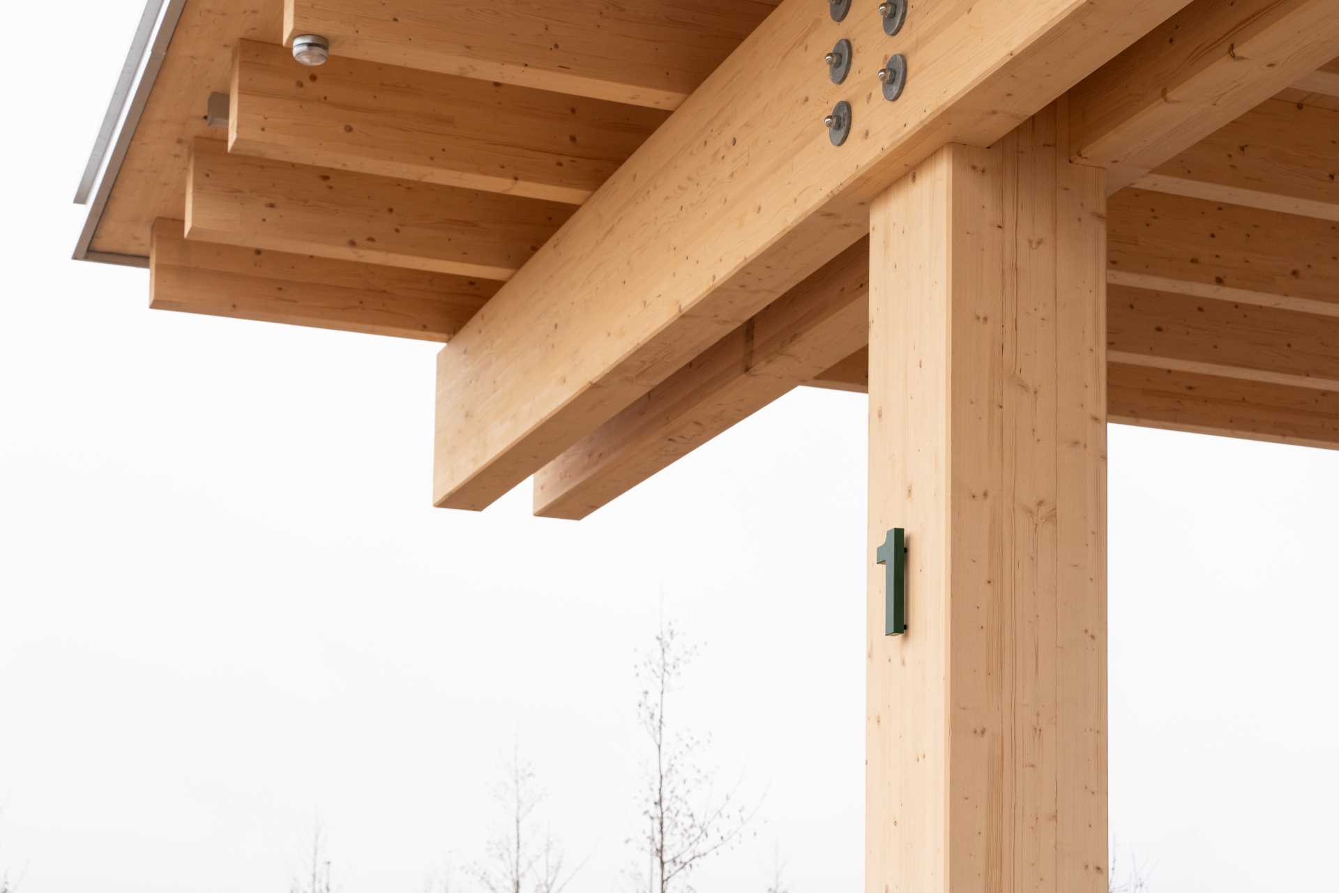 A contemporary charging station that includes a wood structure and a green roof.