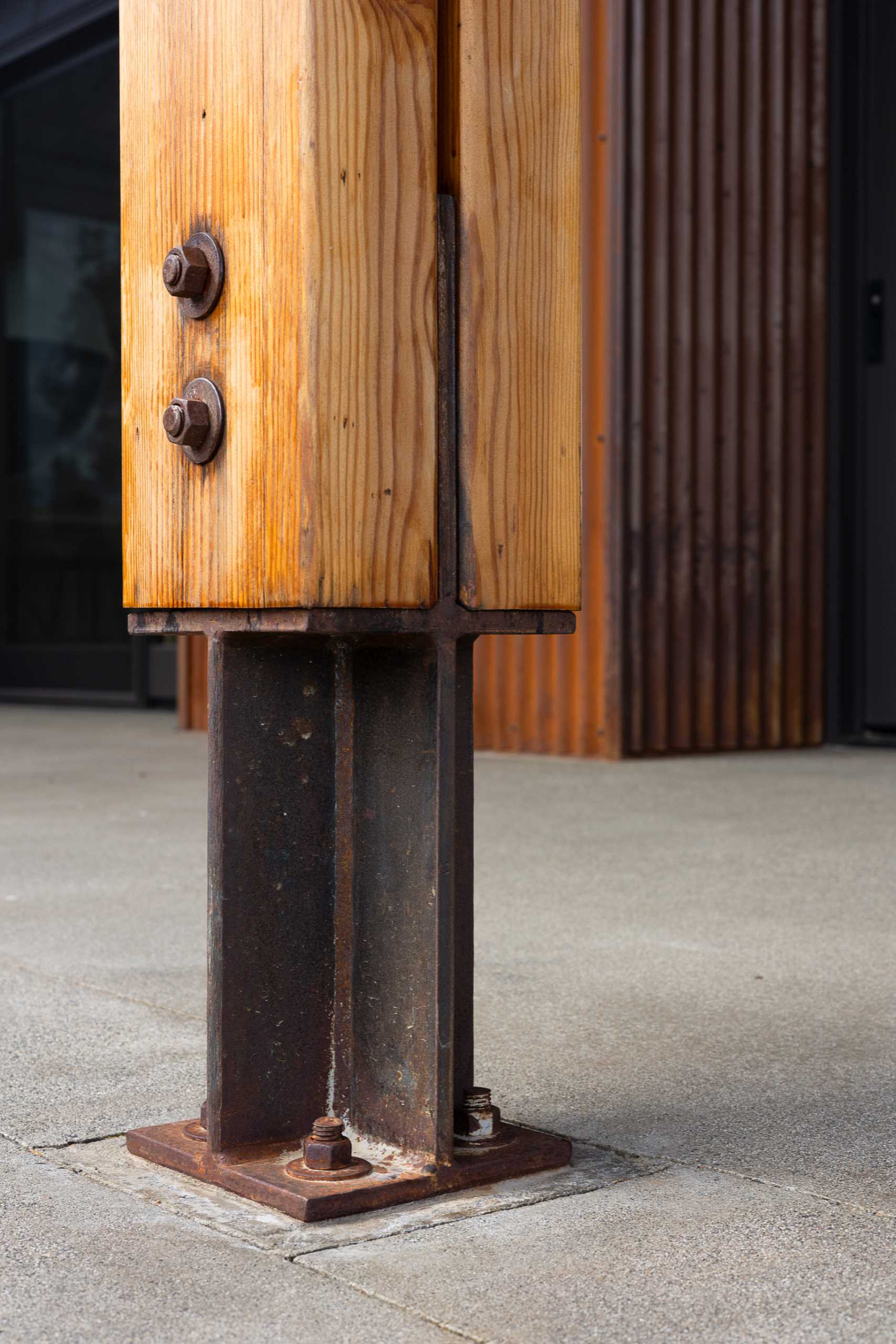 A contemporary home has steel “feet” at the bottom of the doubled glulam columns.