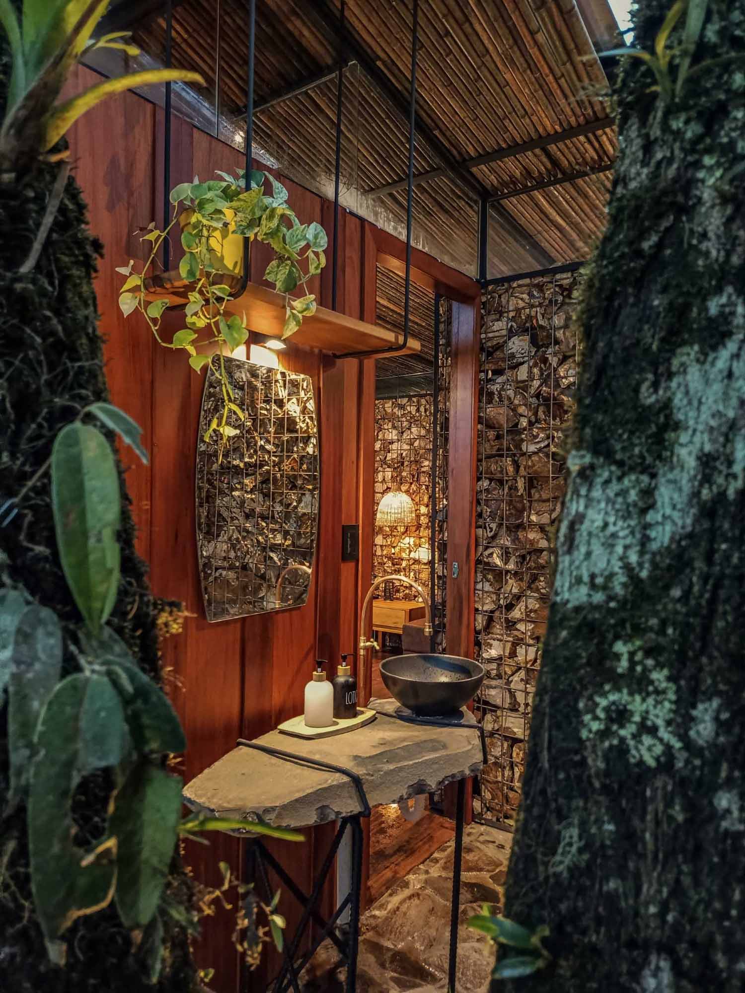 A room in the jungle includes a sleeping area, bathroom, and a balcony.