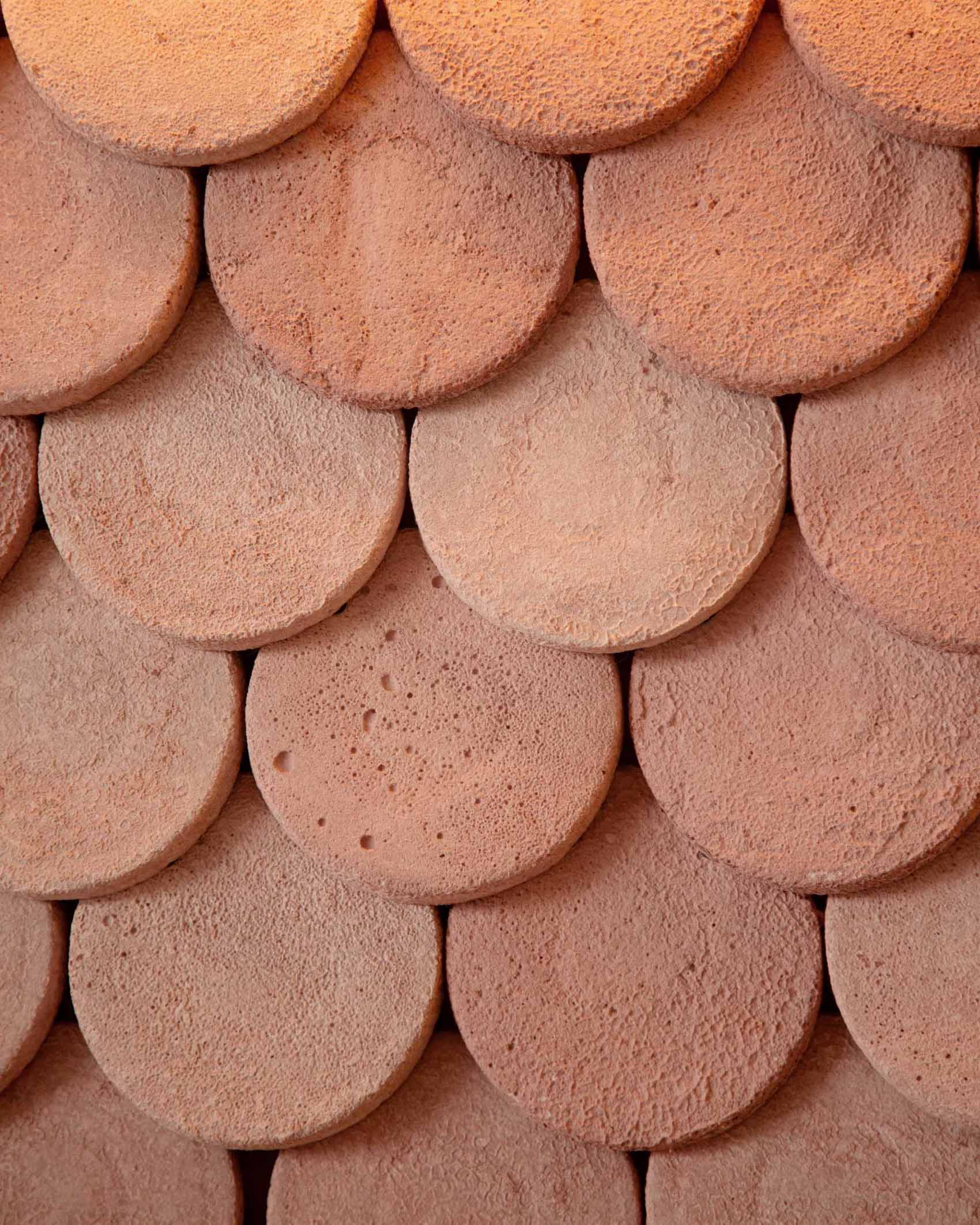 A modern bakery with a pastel pink colour palette, also includes handcrafted pieces of dyed cement that make up the cladding of the bar front.