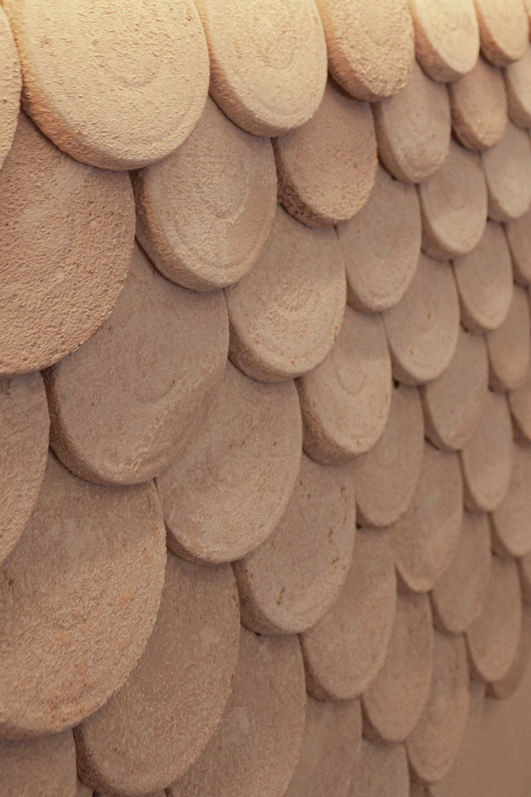 A modern bakery with a pastel pink colour palette, also includes handcrafted pieces of dyed cement that make up the cladding of the bar front.