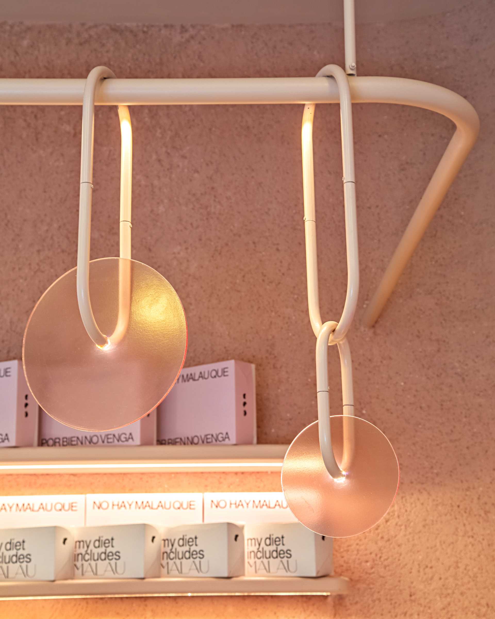 A modern bakery with a pastel pink colour palette, also includes handcrafted pieces of dyed cement that make up the cladding of the bar front.