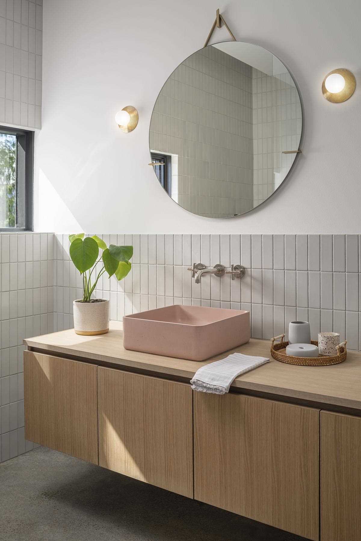 In the bedroom, tiles cover most of the walls, while the floating wood vanity and a plant add a natural element to the space.