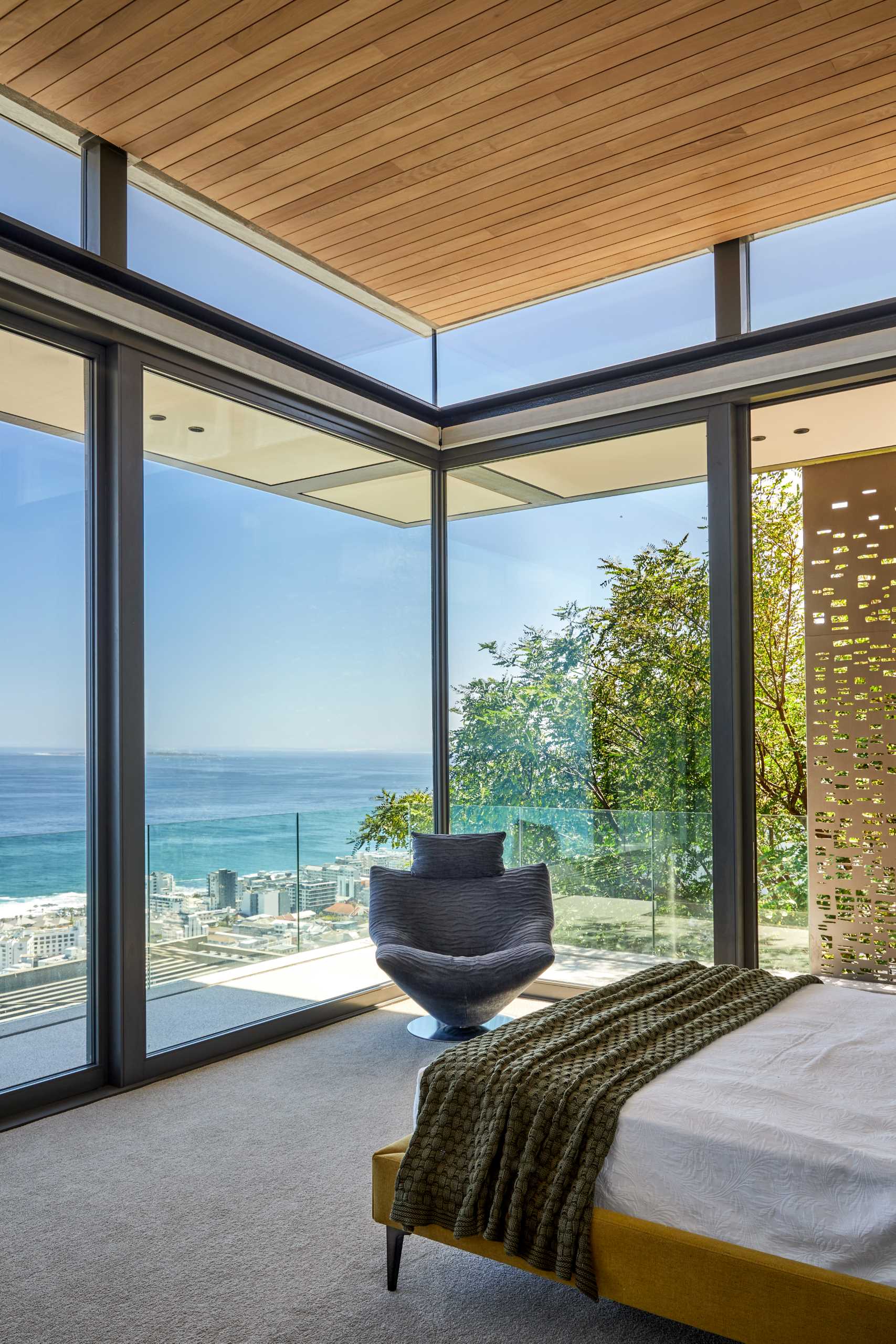 A modern bedroom with floor-to-ceiling windows to take advantage of the views.