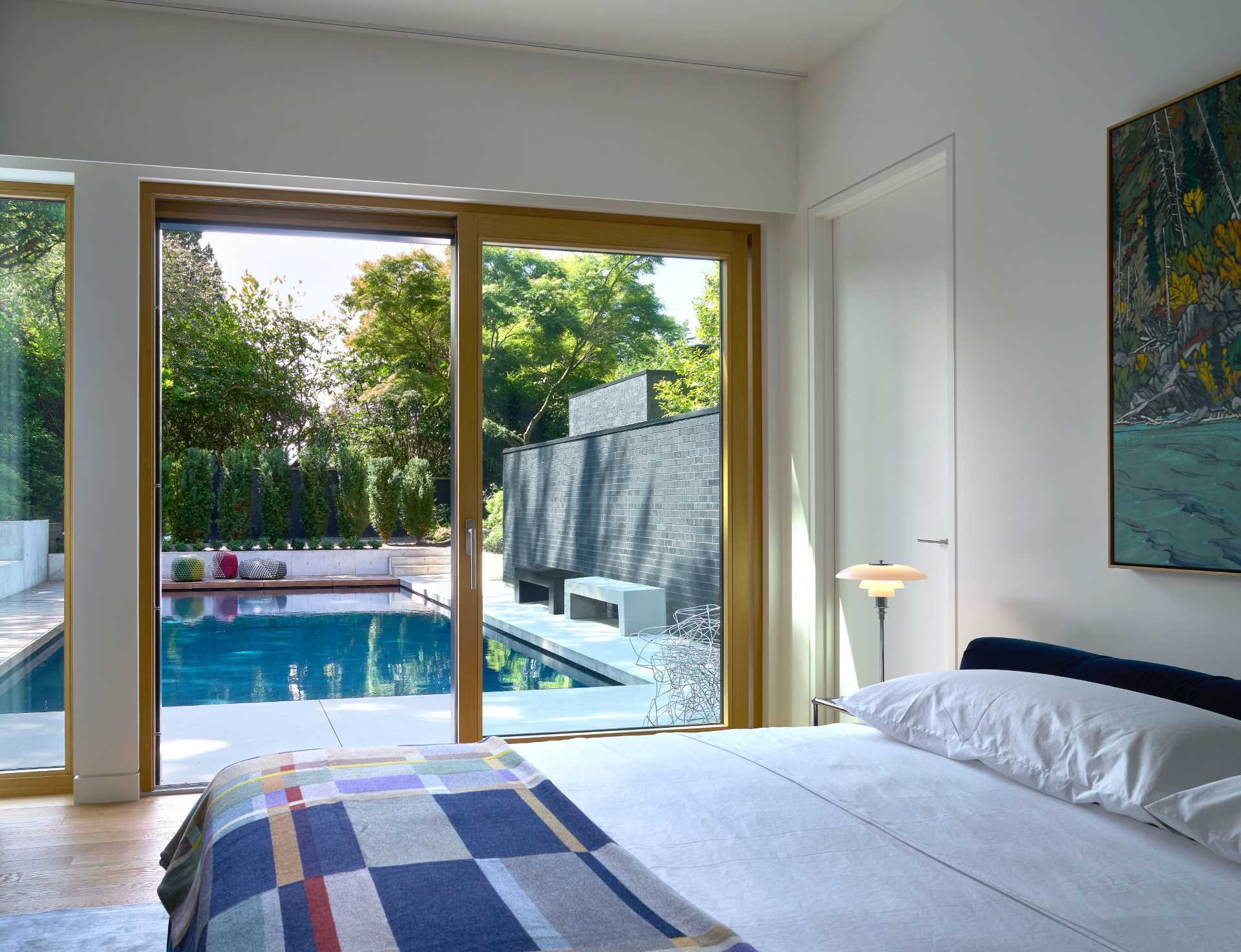 A modern bedroom with a sliding door that opens to the outdoor spaces.