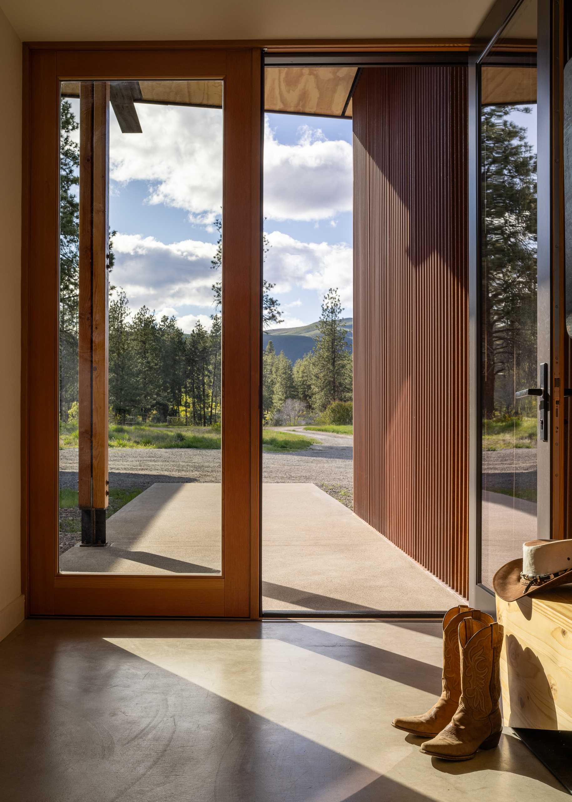 A contemporary home on a ranch clad with weathered corrugated metal siding.