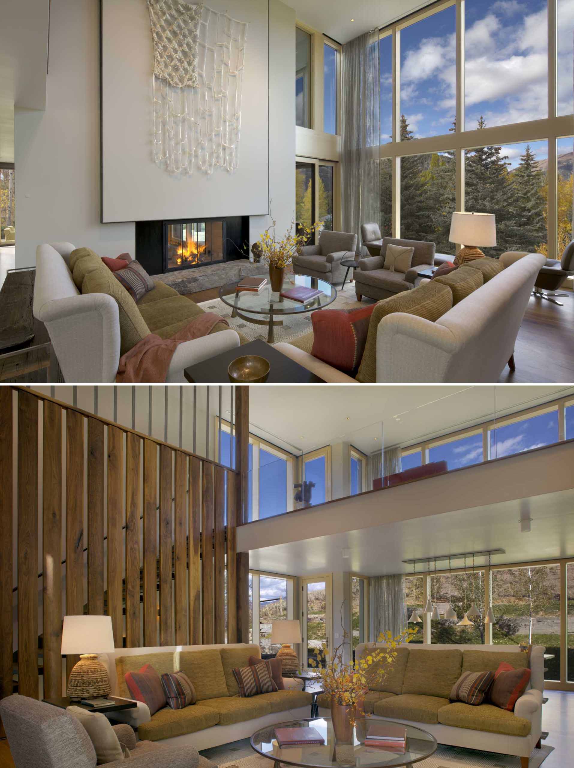 In this living room, an artful American flag hangs over the living room fireplace, while the double height windows floods the room with natural light, and the wood accent wall adds a natural element to the space.