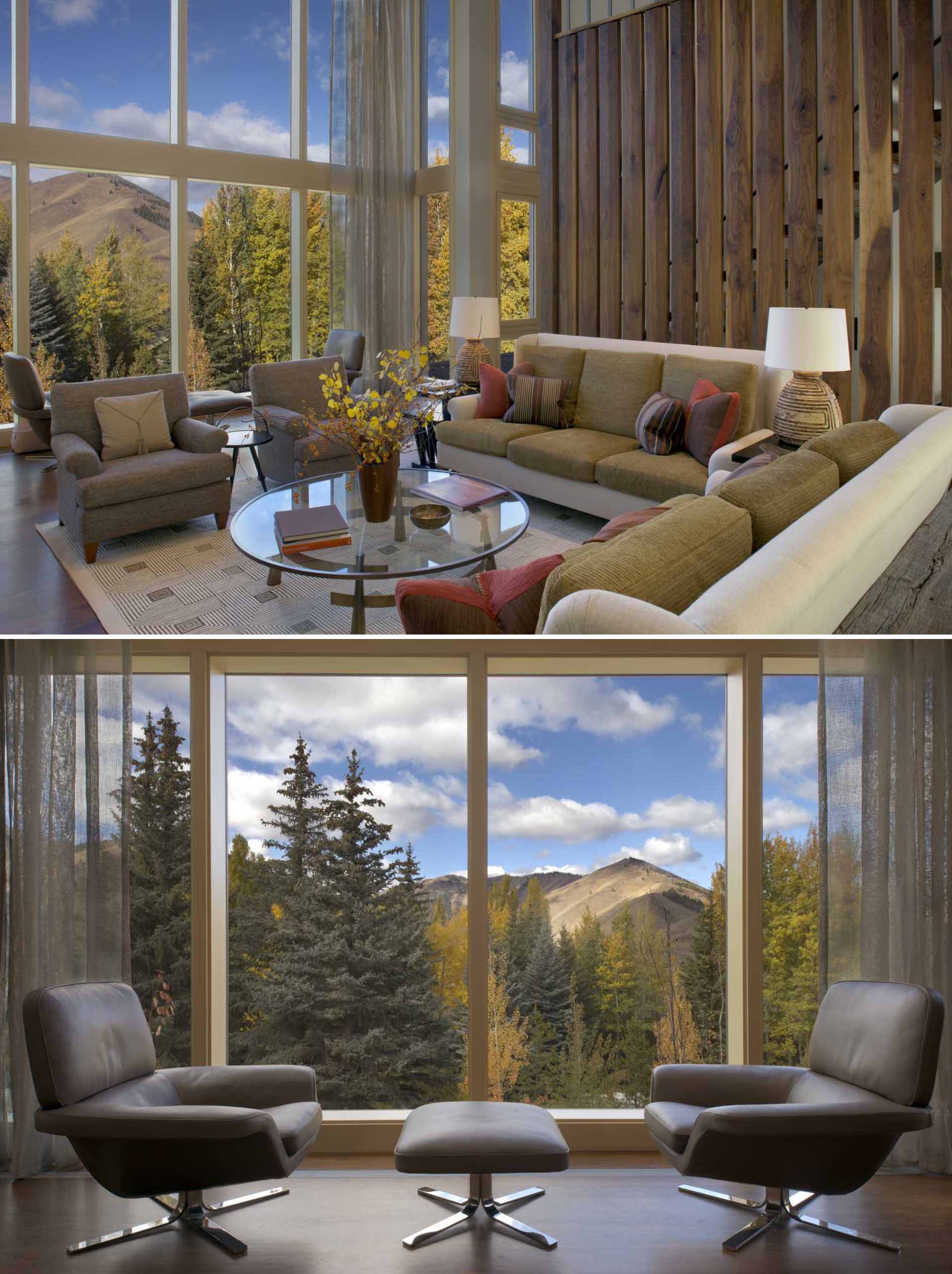 In this living room, an artful American flag hangs over the living room fireplace, while the double height windows floods the room with natural light, and the wood accent wall adds a natural element to the space.