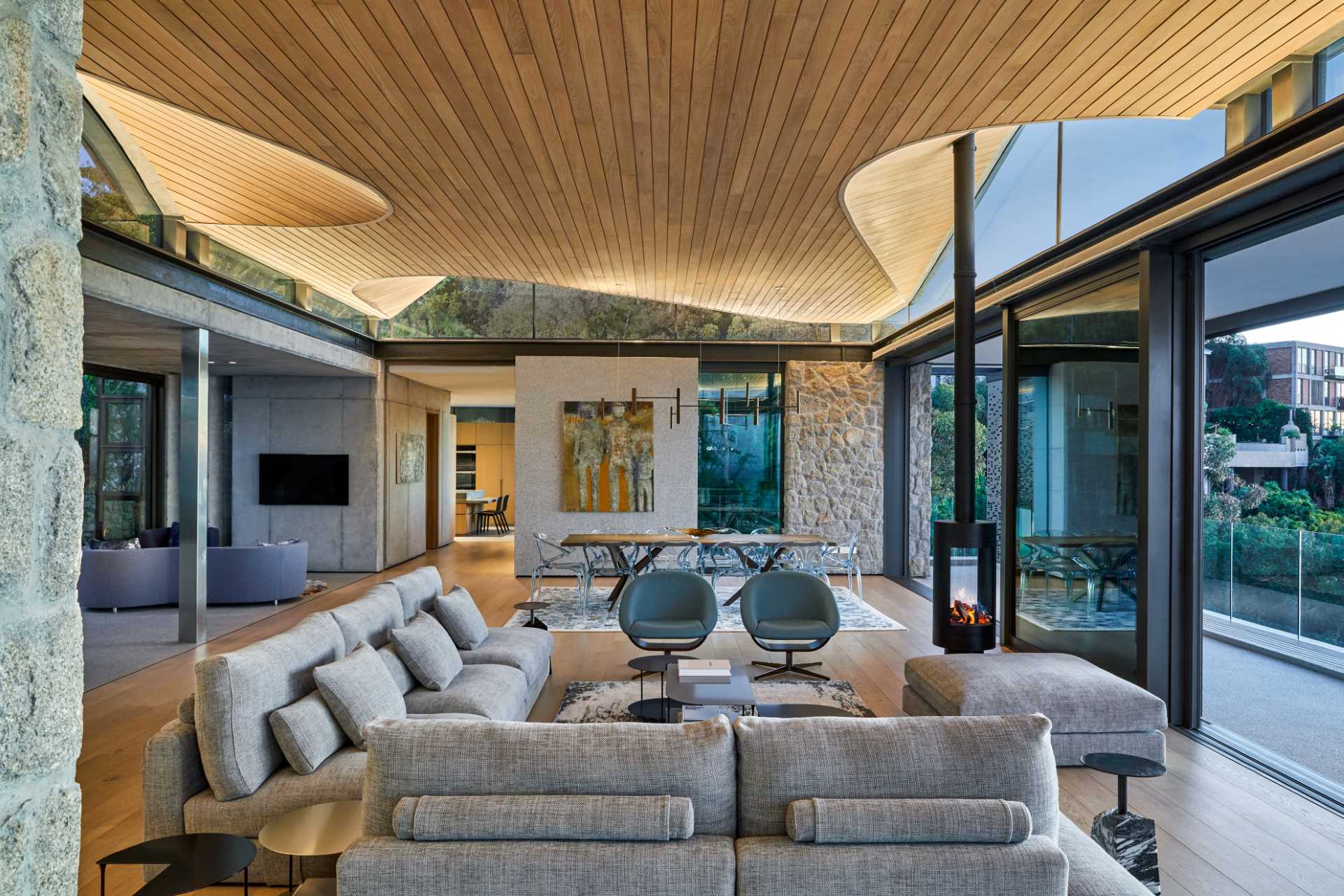 A modern home interior with clerestory windows and an undulating wood-lined ceiling.