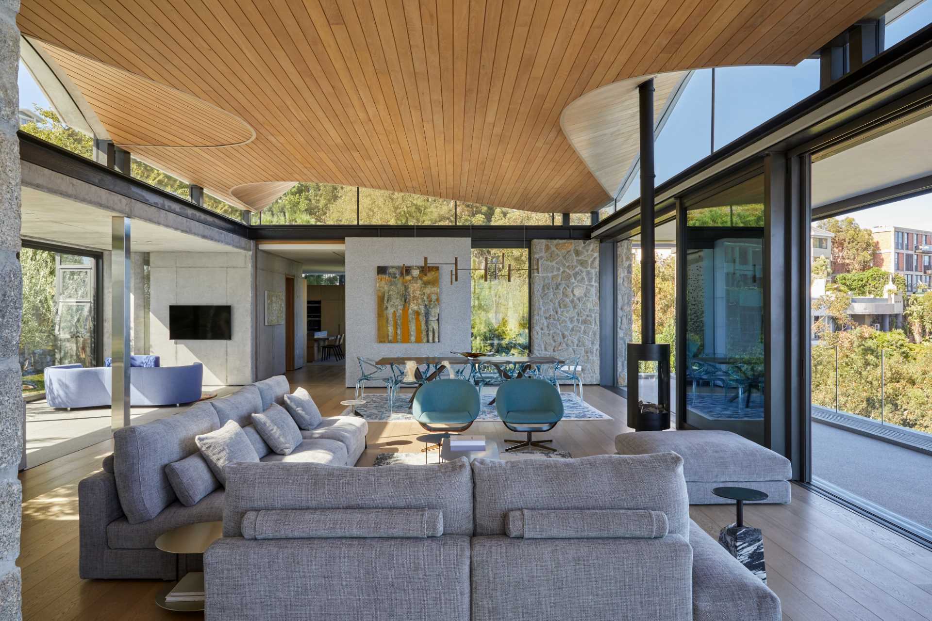 A modern home interior with clerestory windows and an undulating wood-lined ceiling.