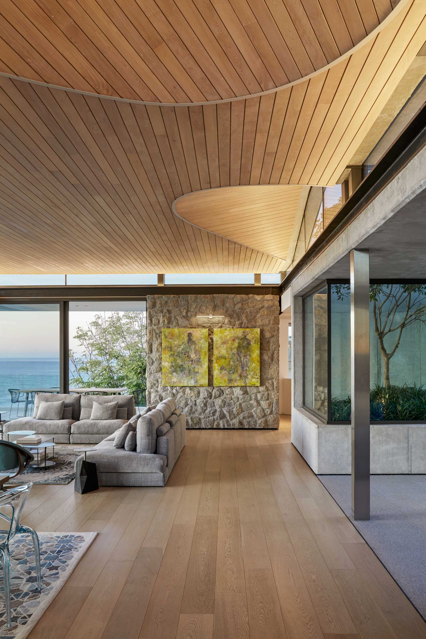 A modern home interior with clerestory windows and an undulating wood-lined ceiling.