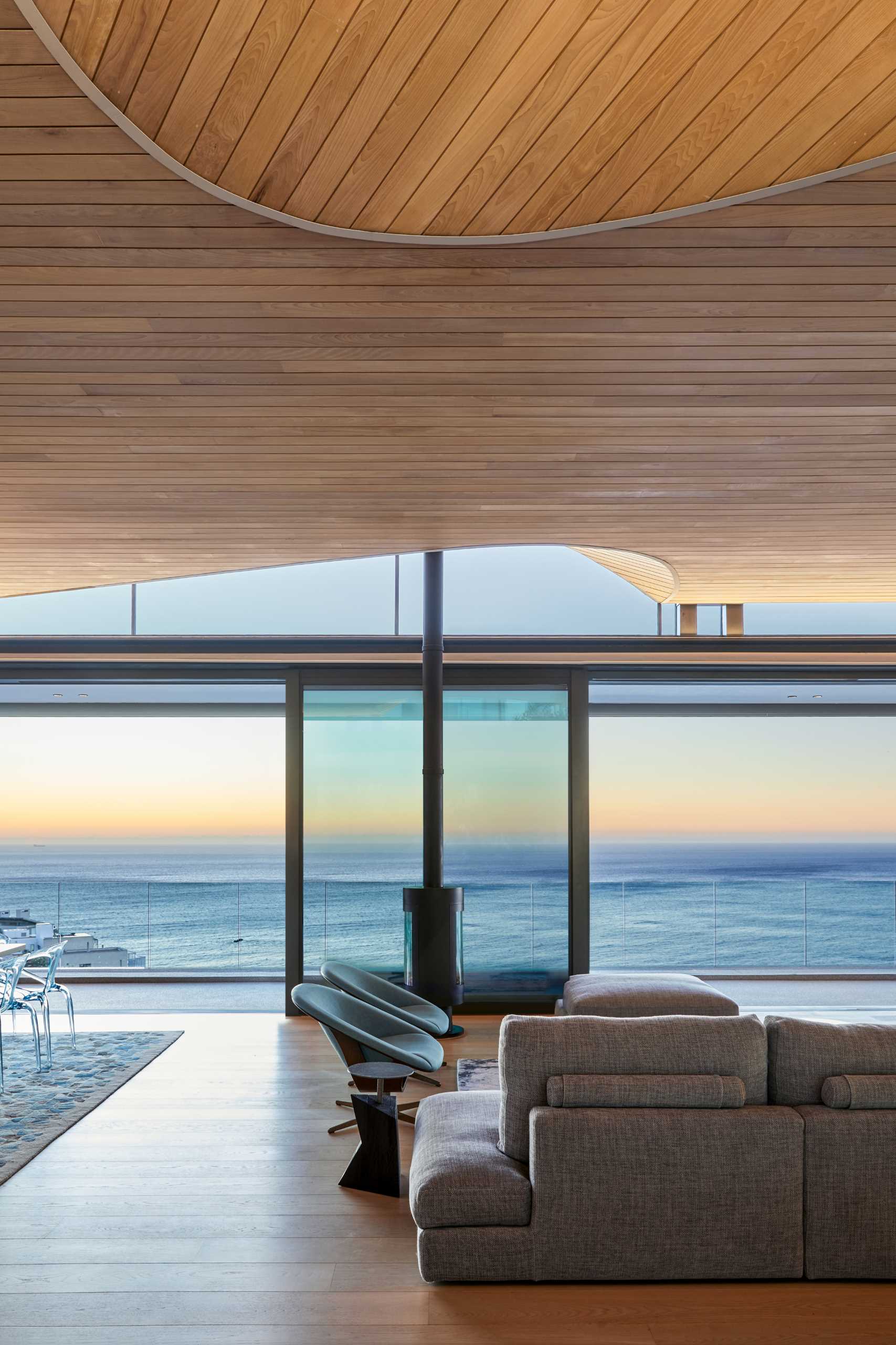 A modern home interior with clerestory windows and an undulating wood-lined ceiling.