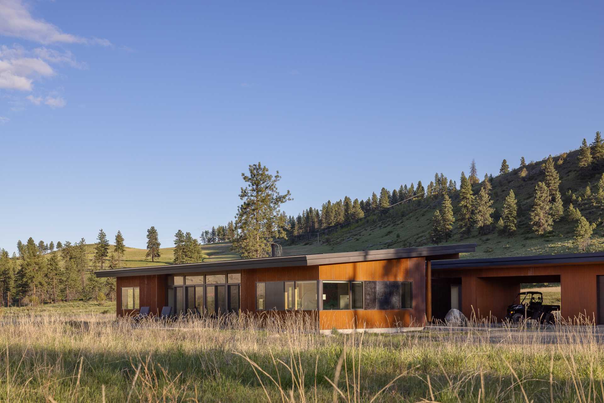 A contemporary home on a ranch clad with weathered corrugated metal siding.