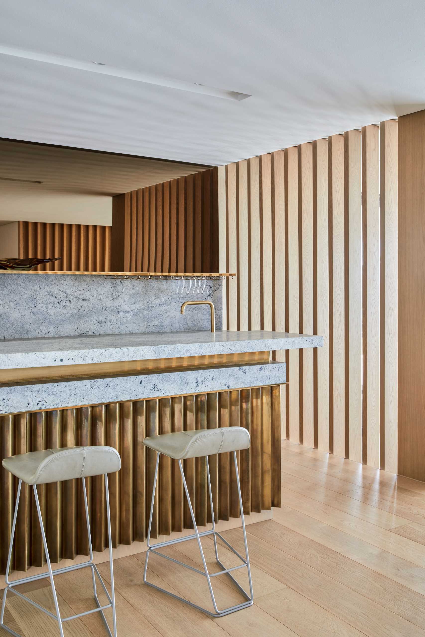 A modern home bar that includes materials like wood, copper, brass, and Cape Granite.