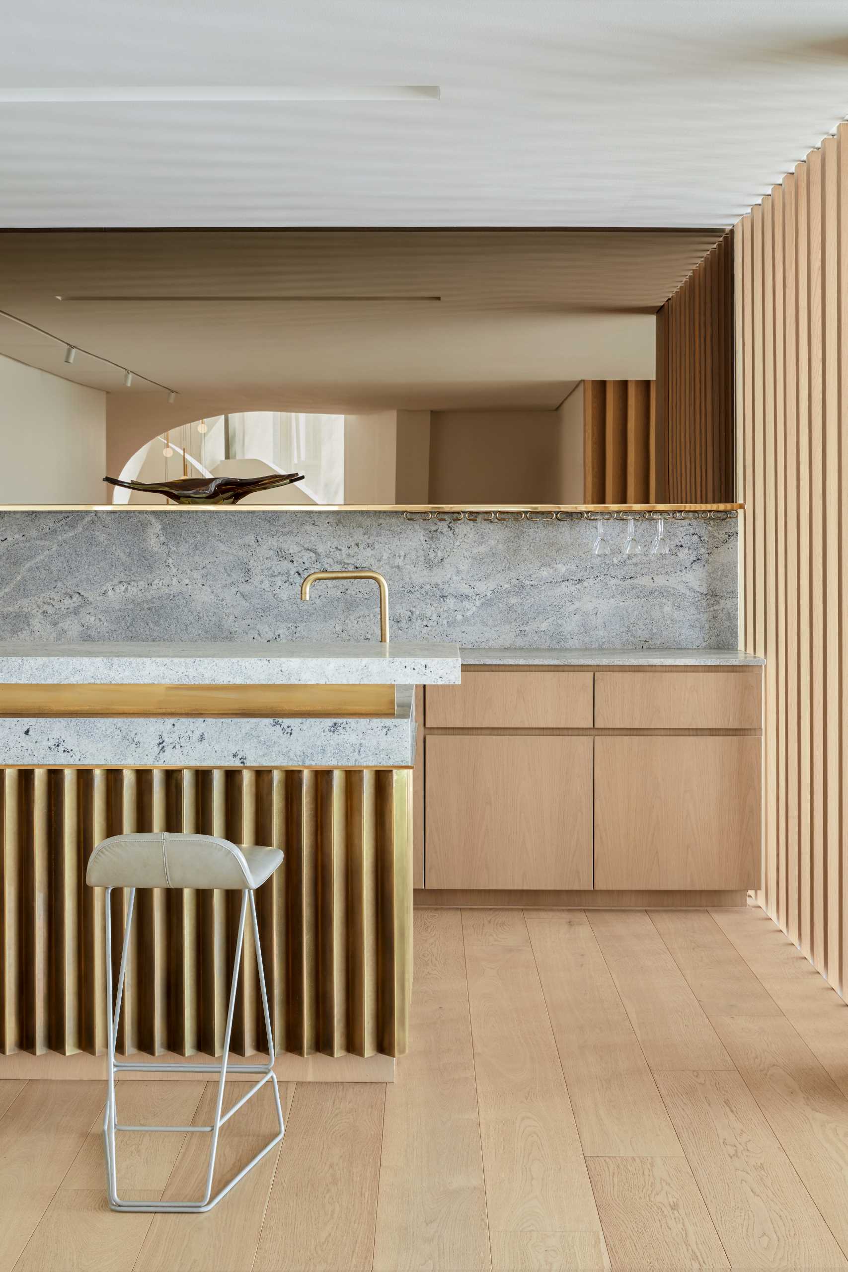 A modern home bar that includes materials like wood, copper, brass, and Cape Granite.