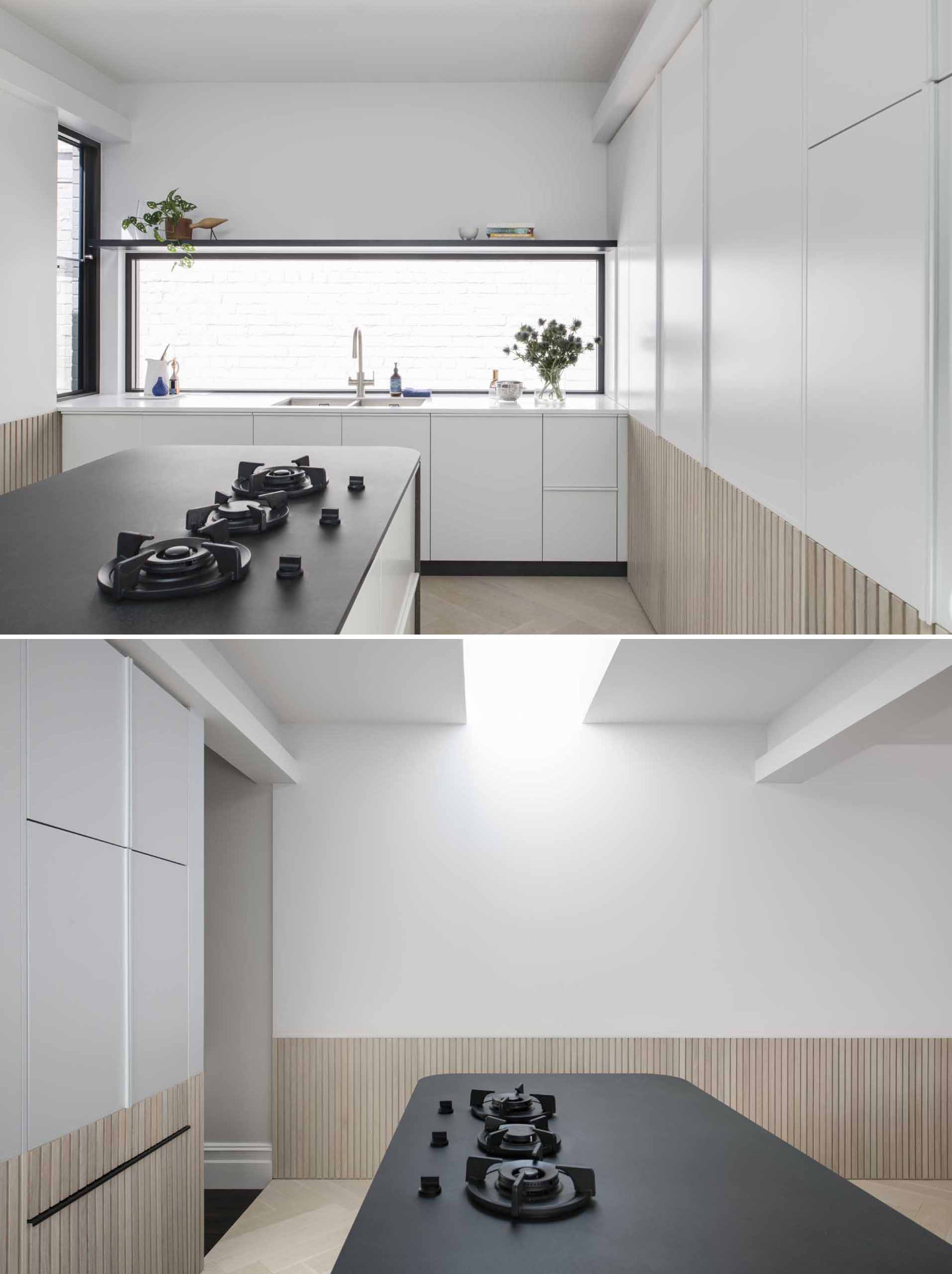 A modern white kitchen with wood paneling around the lower section of the cabinets. Integrated appliances have also been included in the kitchen design.