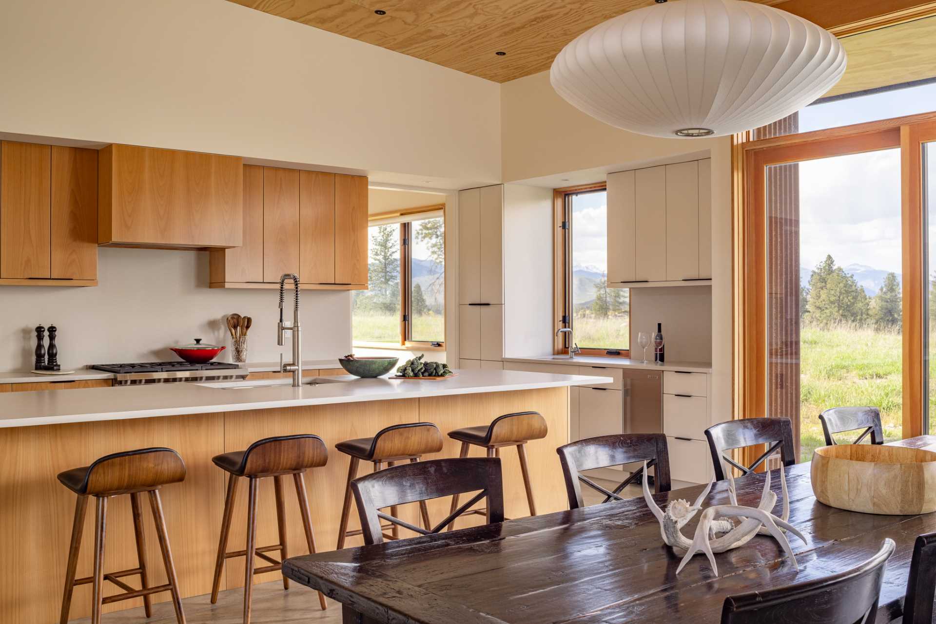 The dining area separates the living room and kitchen, where a mix of wood and white cabinets create a contemporary look.