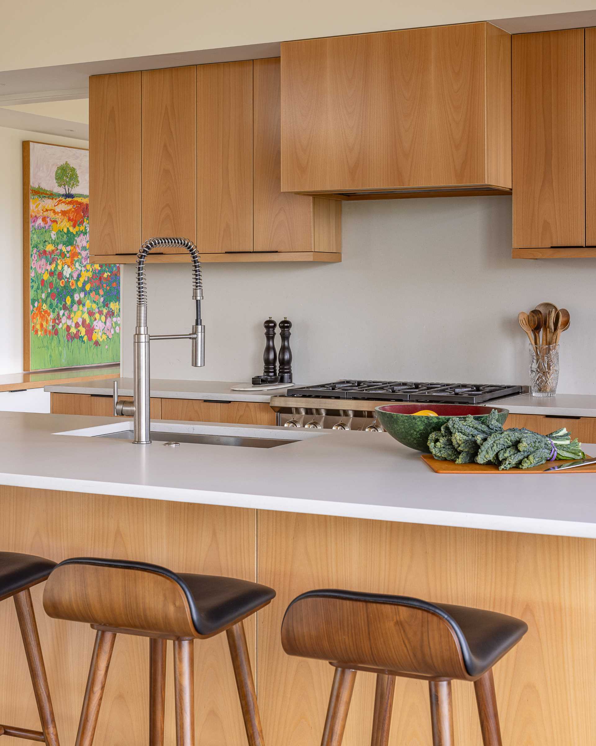 A contemporary kitchen with wood cabinets and white countertops.