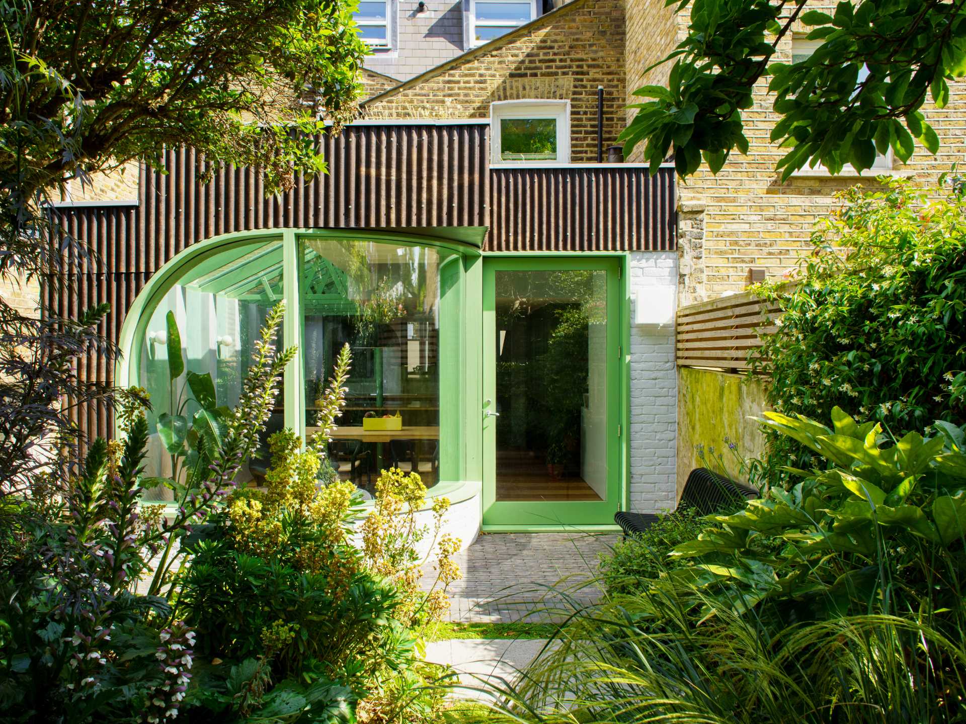 A modern home extension with a curved window, a skylight, and a new dining area and custom kitchen with IKEA cabinets.