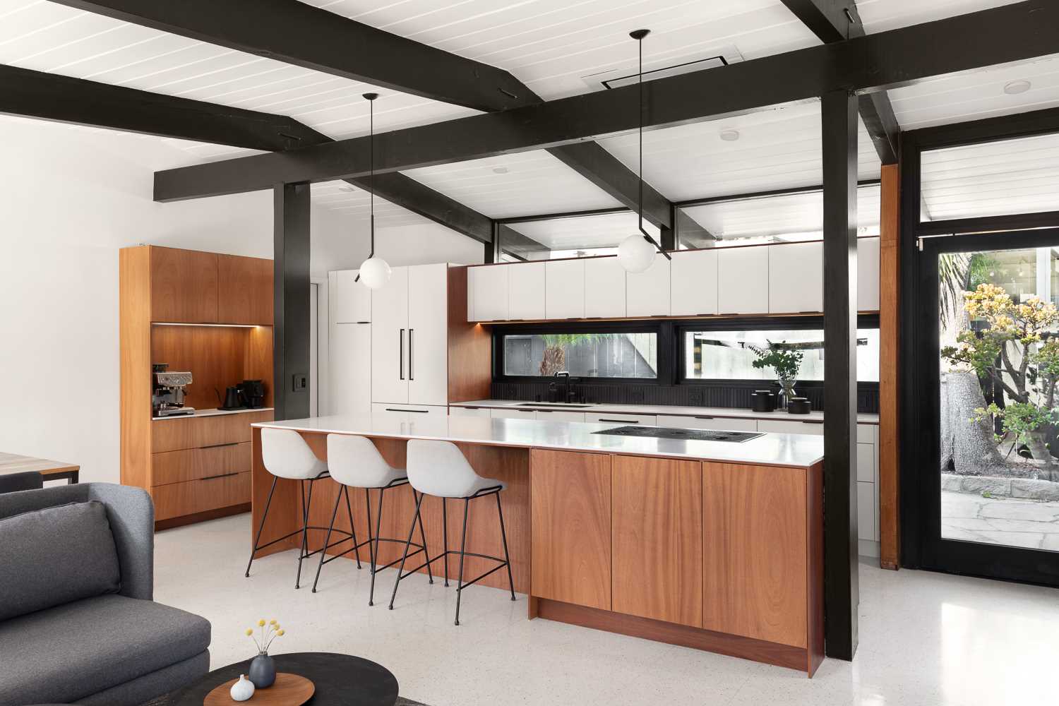 Wood, white, and black served as the clean palette for the new design of this  kitchen in a renovated mid-century modern home.