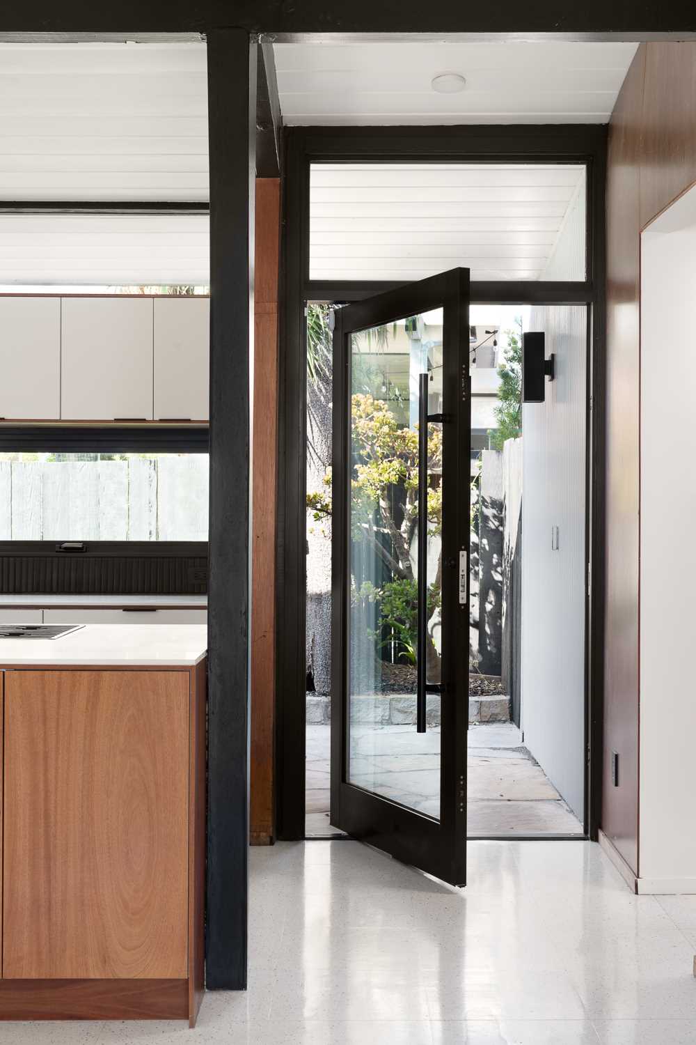 A modern pivoting glass front door.