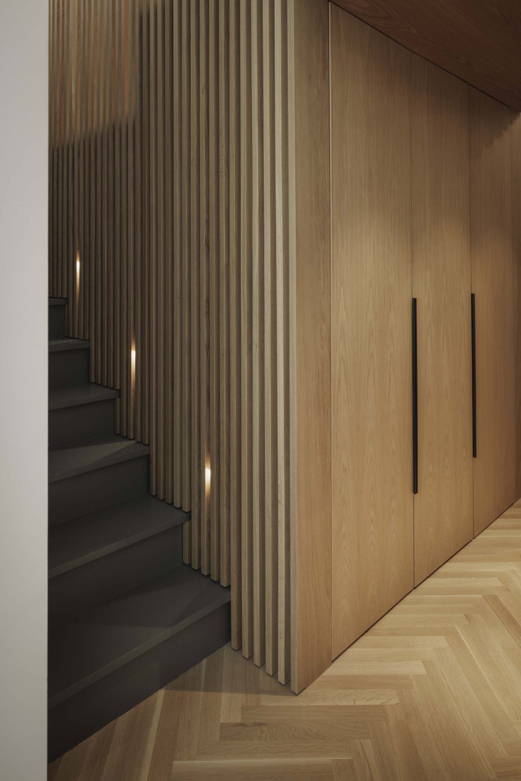 Stairs lead from the main level up to the lofted bedroom. Hidden lighting in the wood slats makes it easy to see the stairs at night.