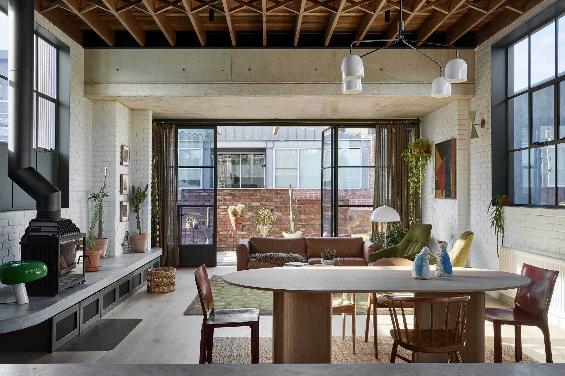 The dining area, with its wood table and chairs, separates the living room from the kitchen.