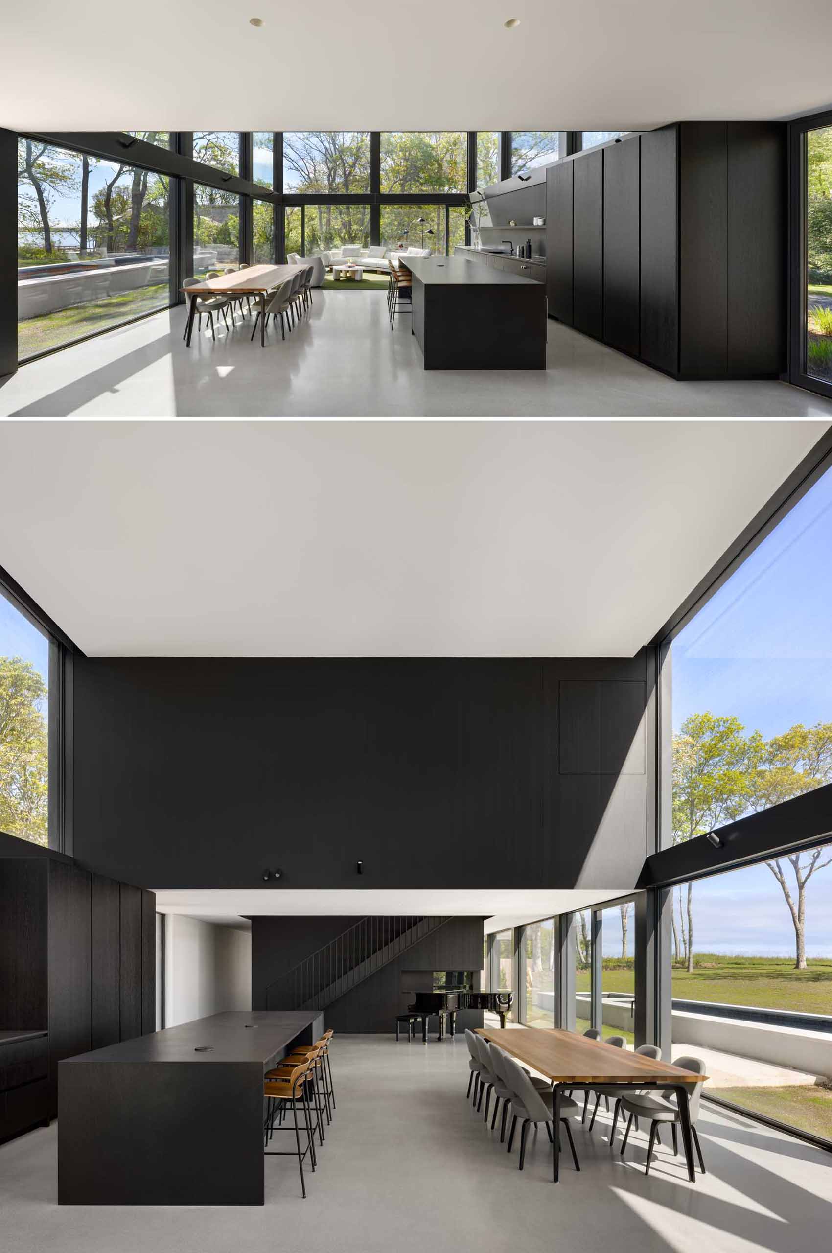 A modern home with large windows, thick black frames, and an open plan interior.