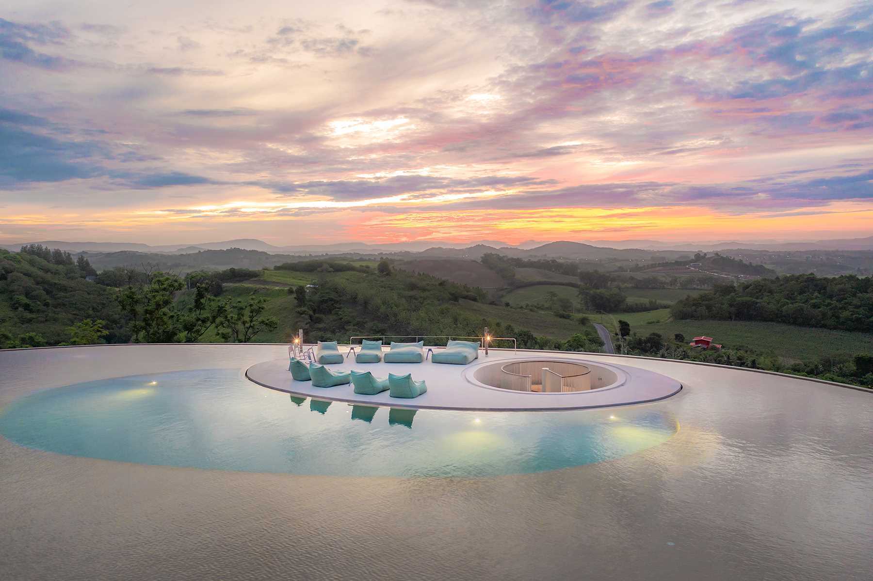 A round pool at the top of a mountain looks down on the surrounding landscape.