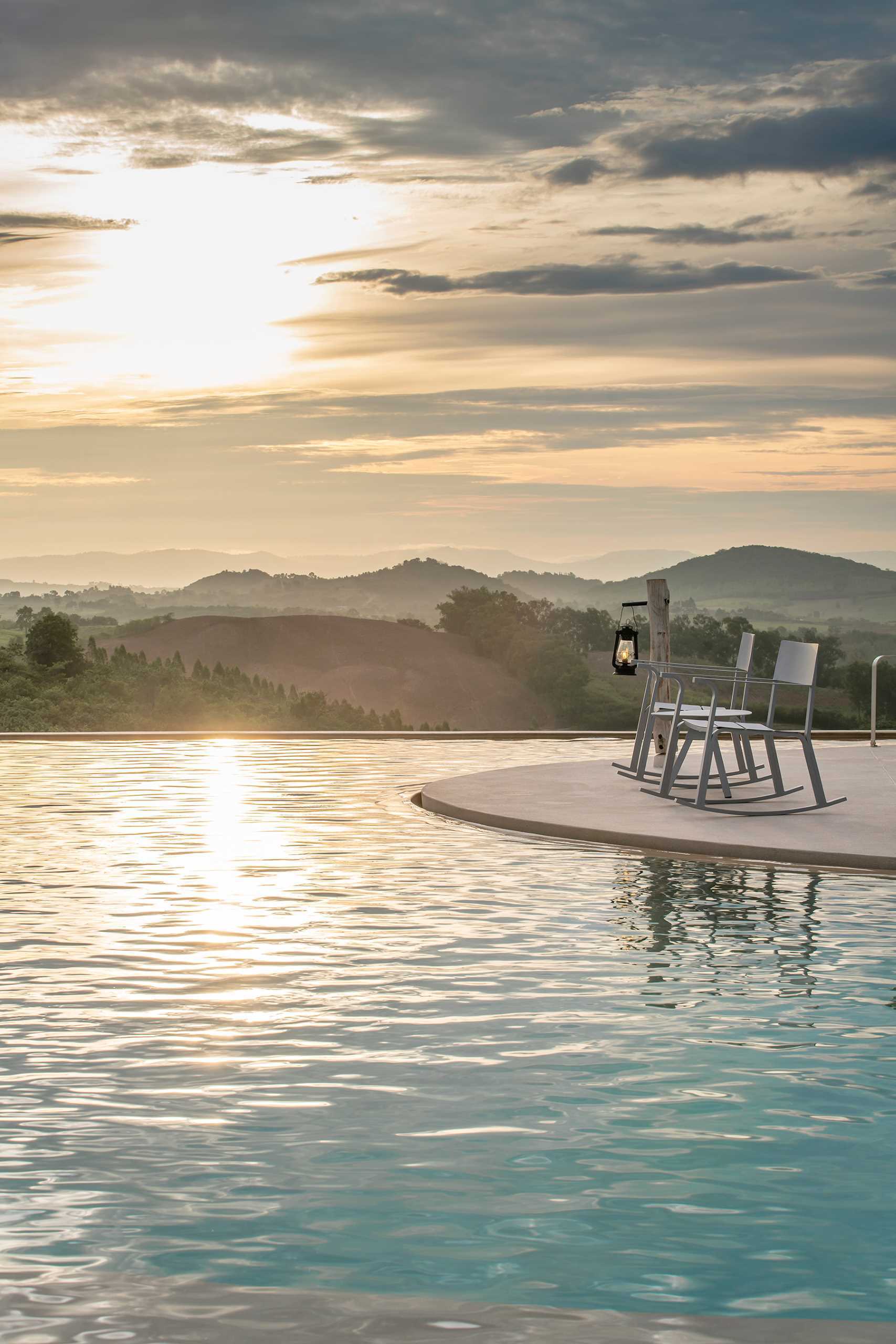 A round pool at the top of a mountain looks down on the surrounding landscape.