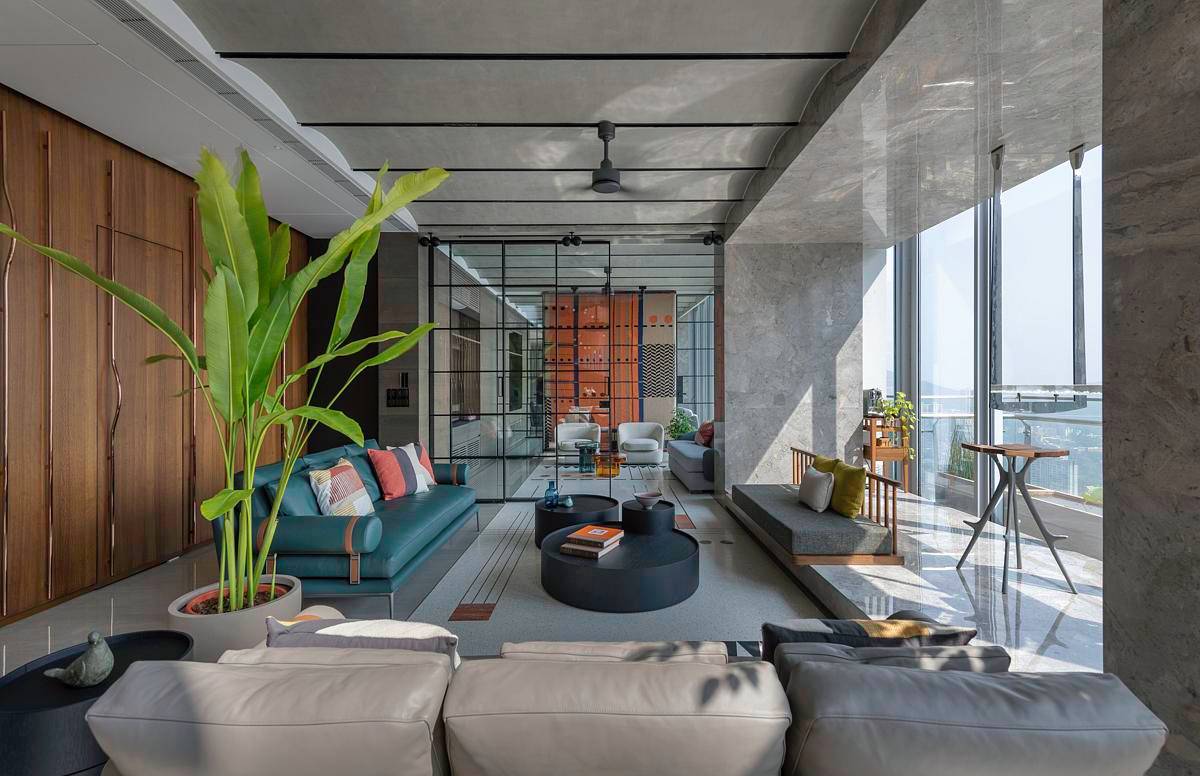 A modern living room in a penthouse, includes orange accents.