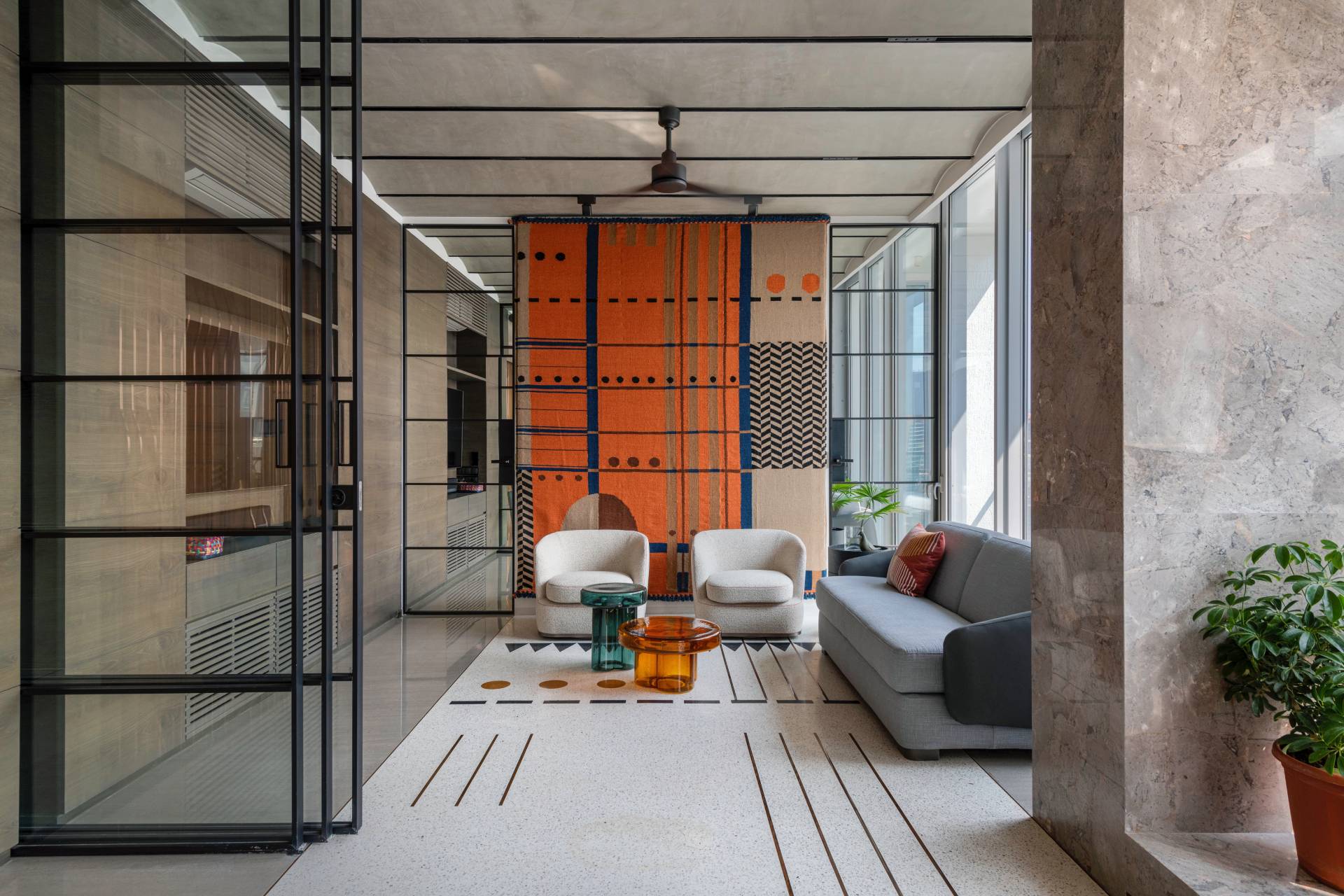 A modern living room in a penthouse, includes orange accents.