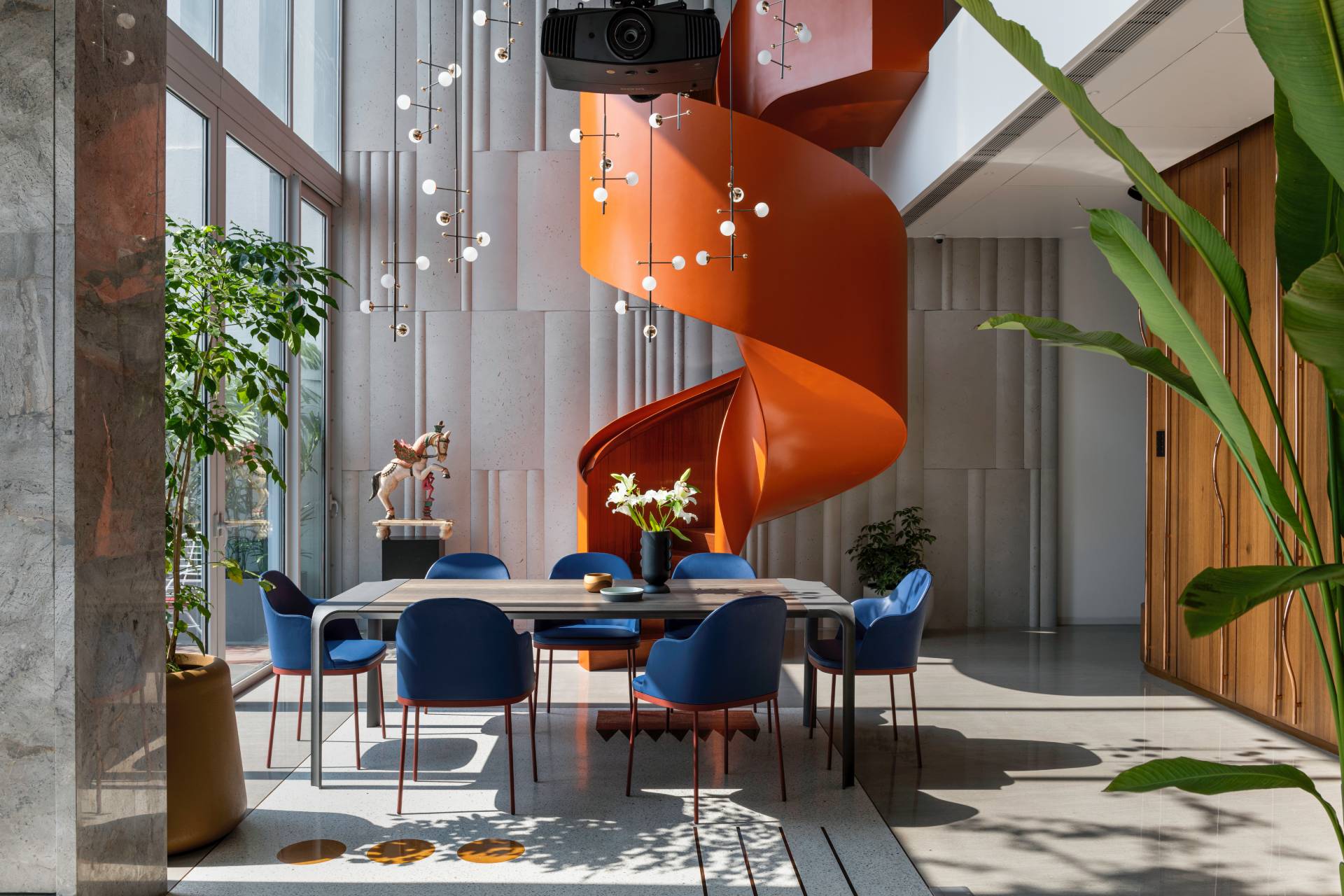 A modern penthouse with a bright orange spiral staircase.