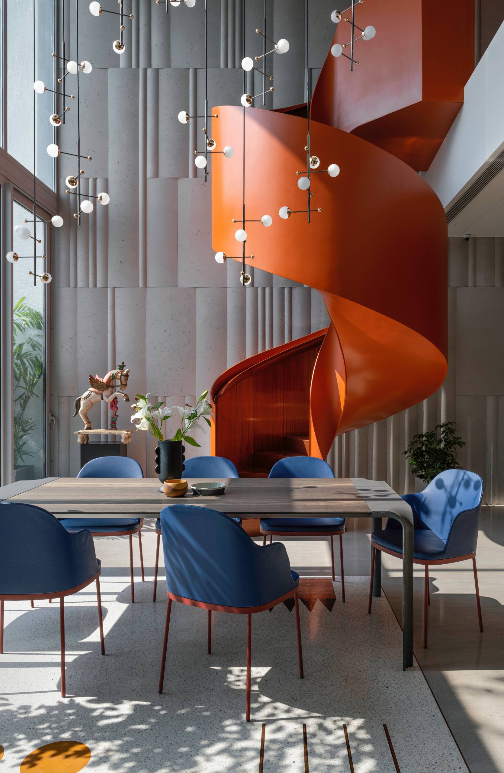 A modern penthouse with a bright orange spiral staircase.