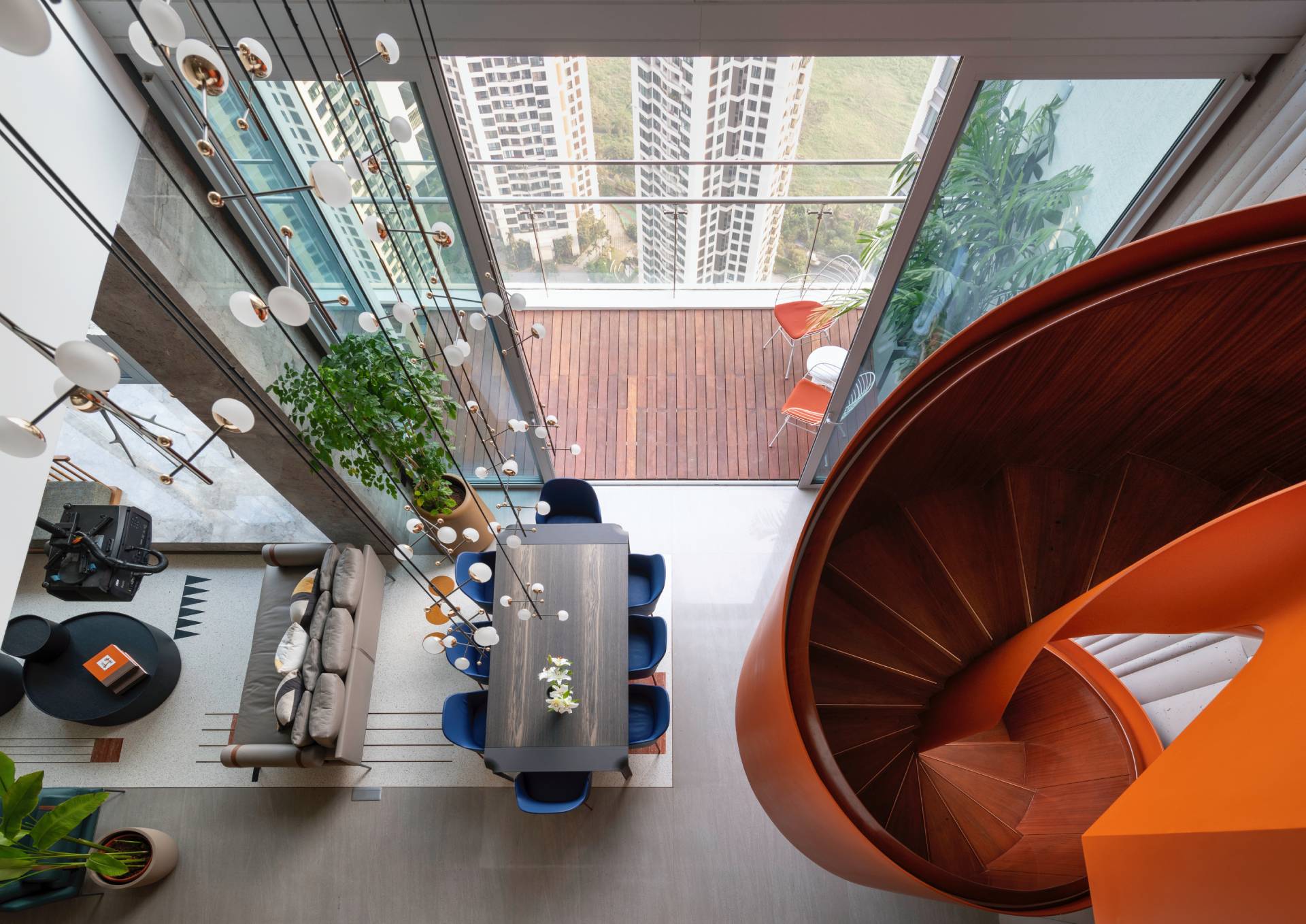 A modern penthouse with a bright orange spiral staircase.