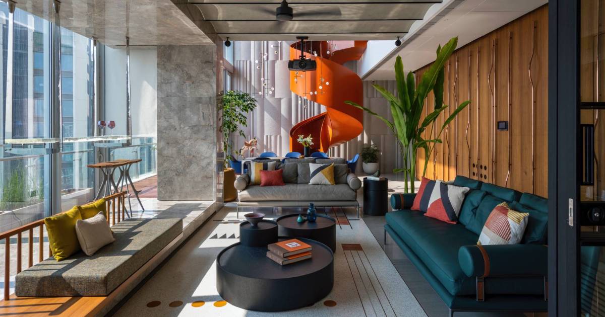 An Orange Spiral Staircase Is An Eye-Catching Feature Inside This Apartment