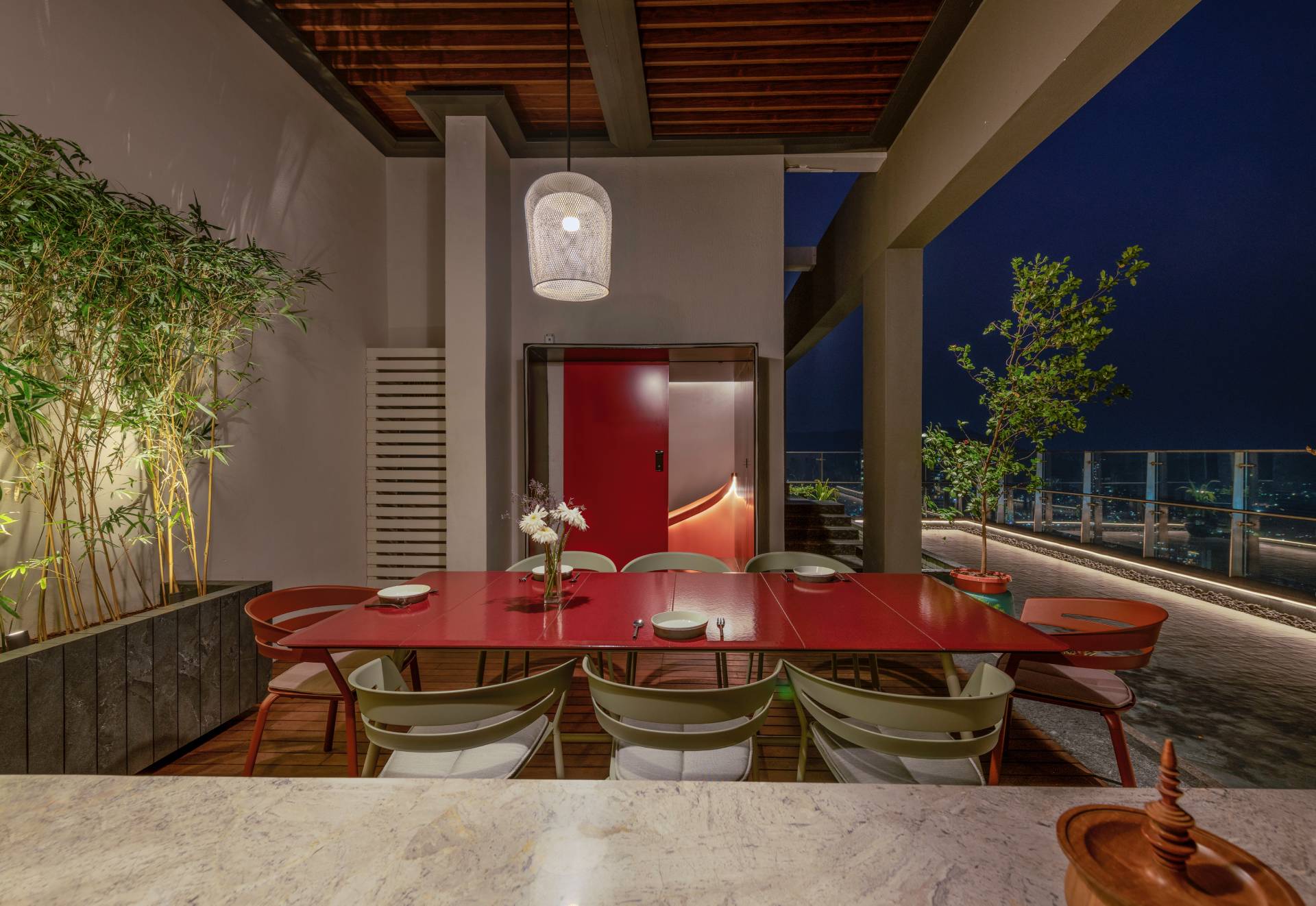 A modern penthouse with a terrace that has a dining area and multiple seating areas.