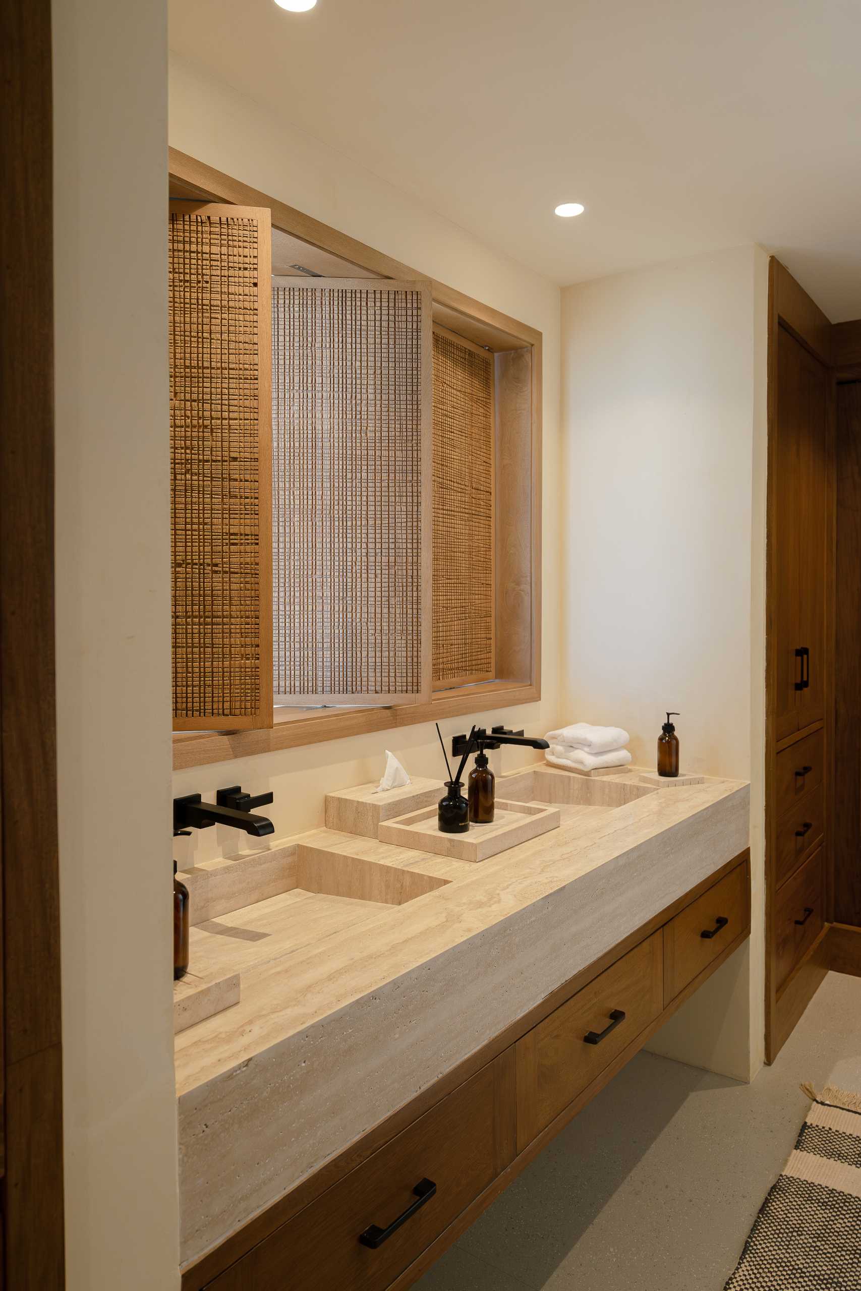 A contemporary bathroom featuring Travertine marble and a neutral palette.