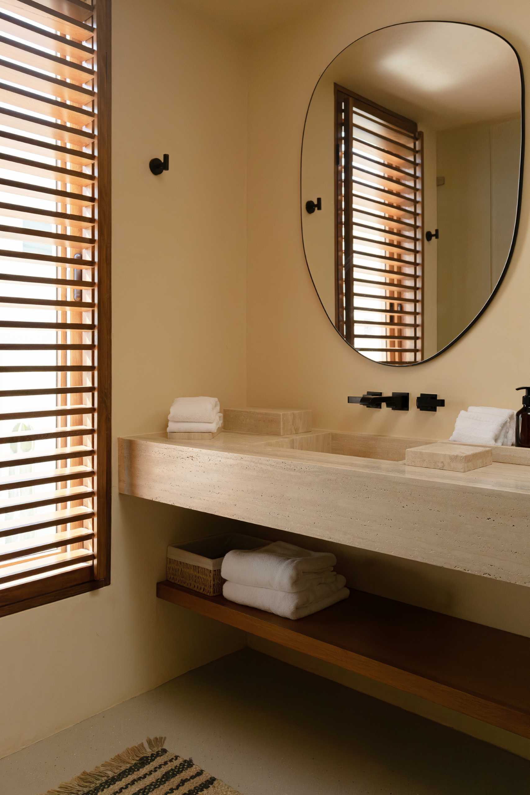 A contemporary bathroom featuring Travertine marble and a neutral palette.