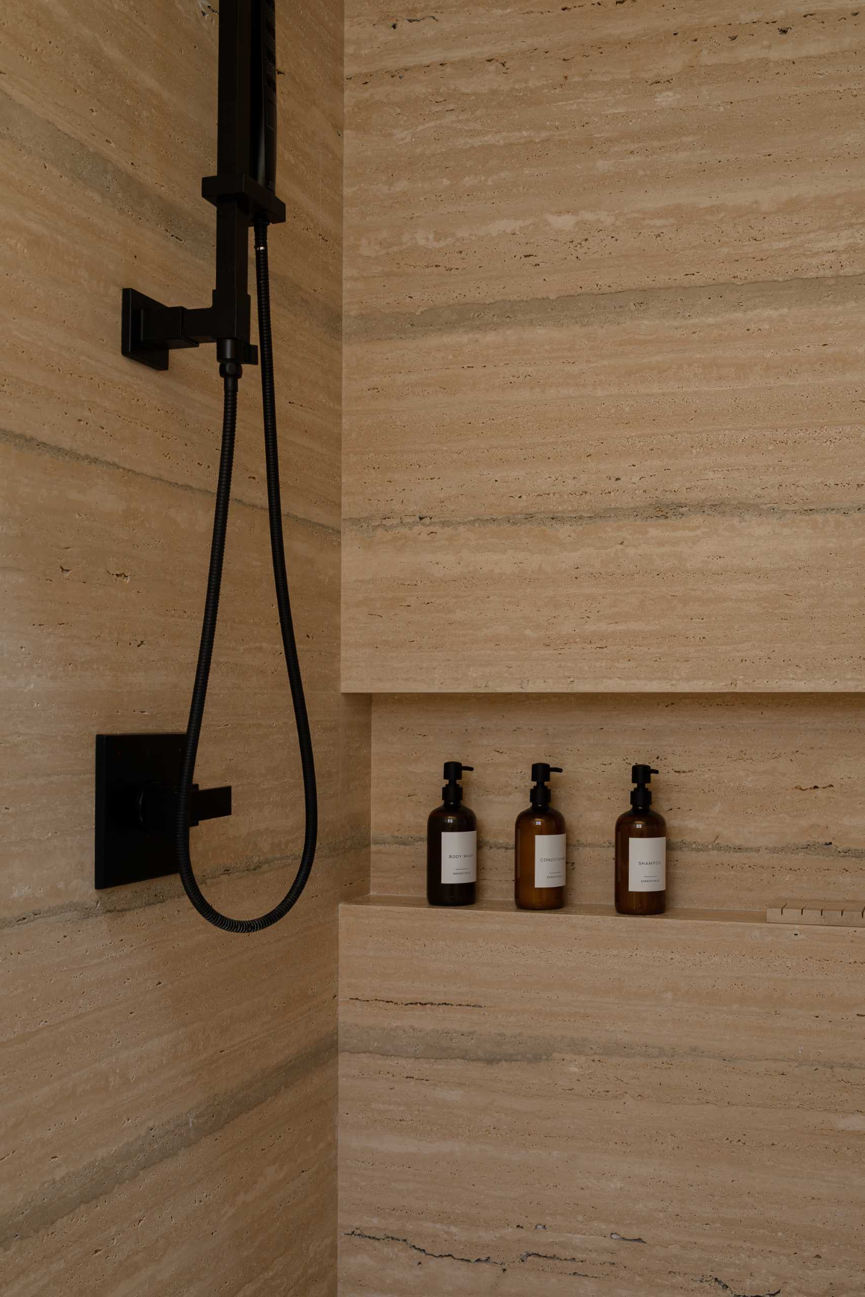 A contemporary bathroom featuring Travertine marble and a neutral palette.