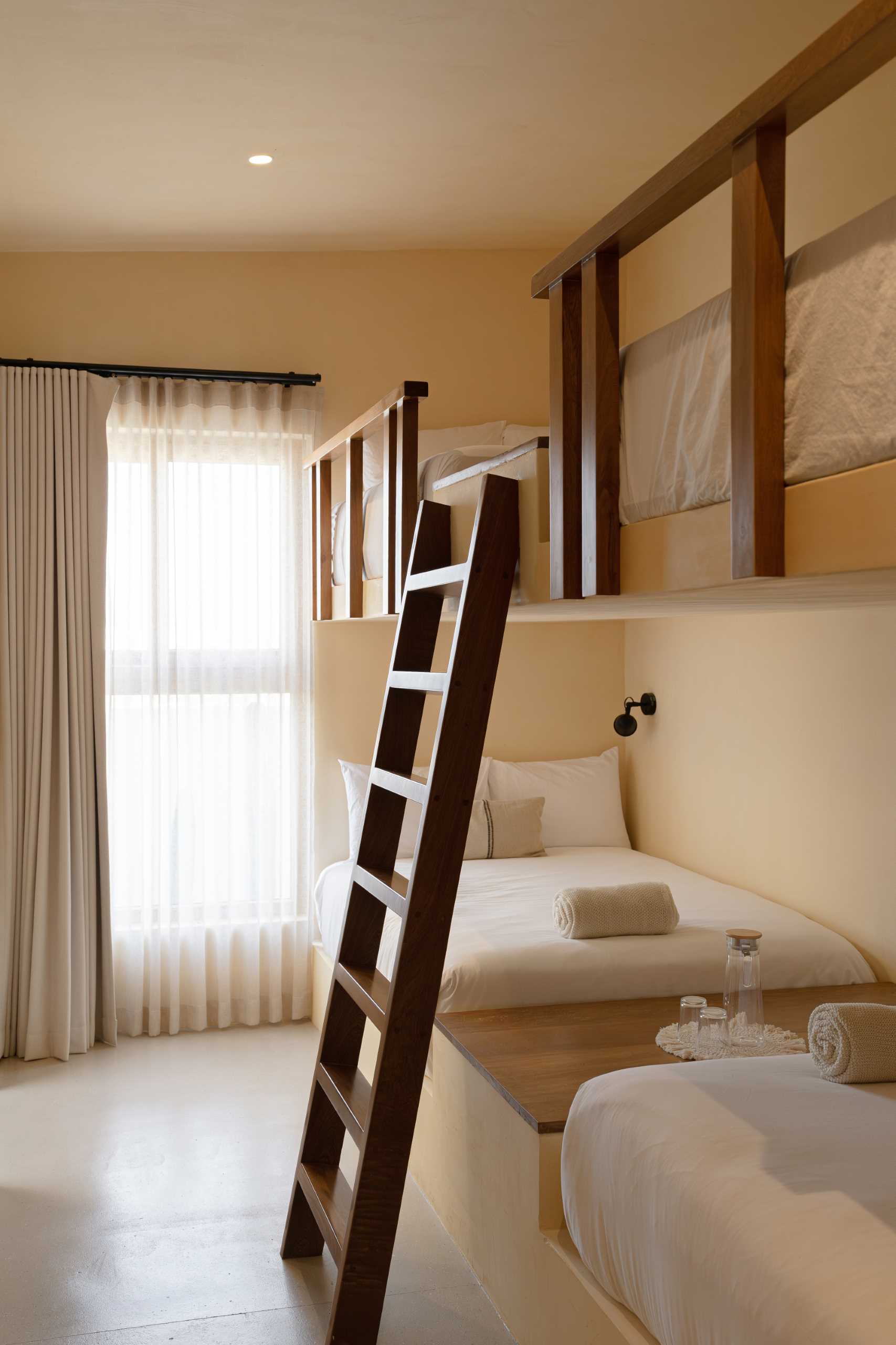 A contemporary bedroom with built-in bunk beds and a neutral palette.