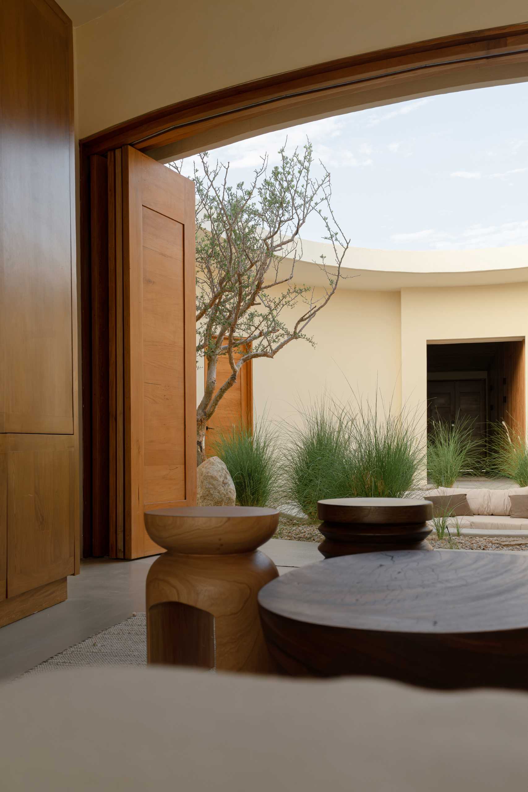 Surrounding the central patio of this contemporary house, the living spaces open fully from the entrance to the beach terrace, allowing for cross-ventilation and seamless integration between spaces.