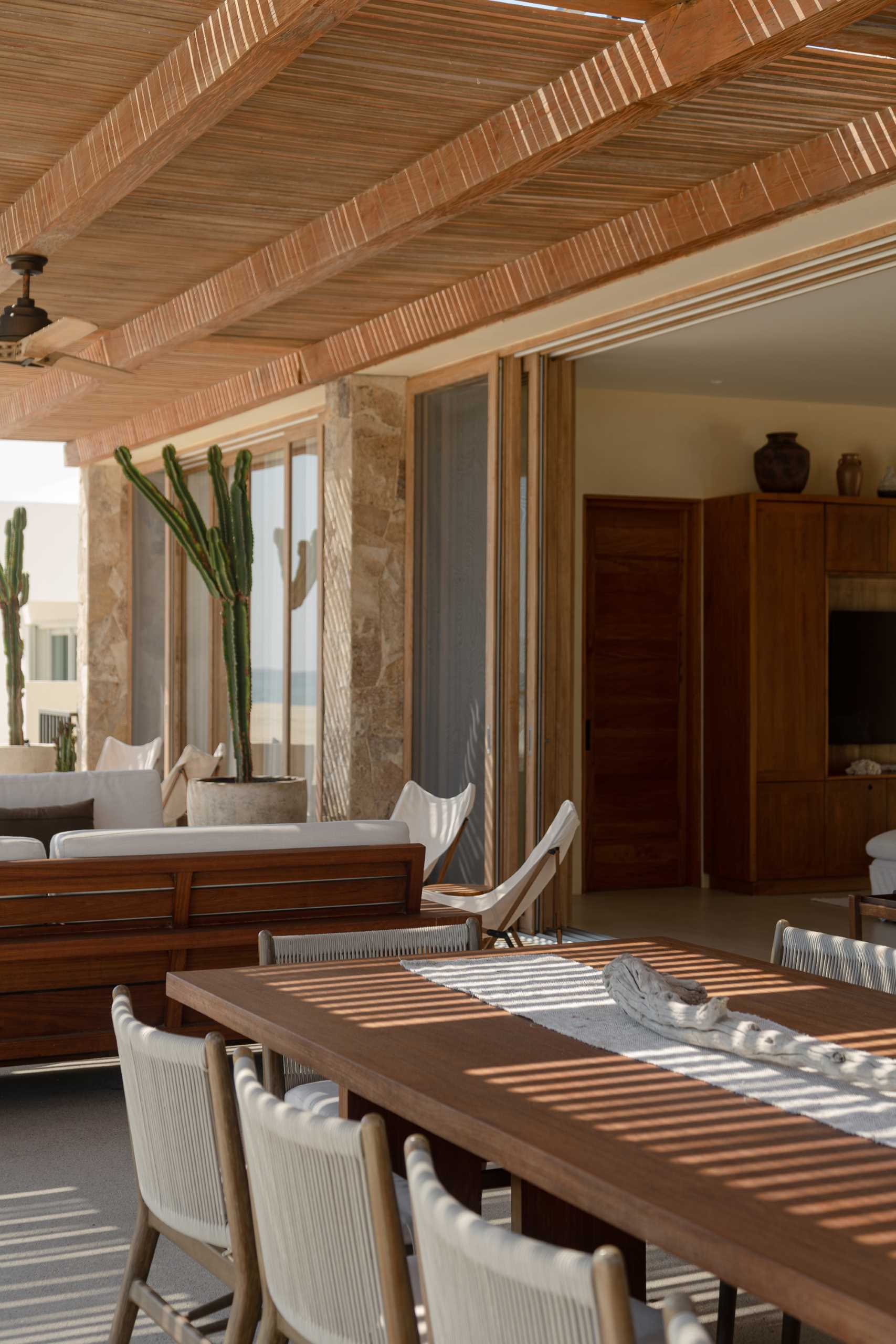 A contemporary stone home includes a spacious terrace, as well as a series of sculptural concrete cubes that form the pool and jacuzzi, while steps lead directly to the sand.