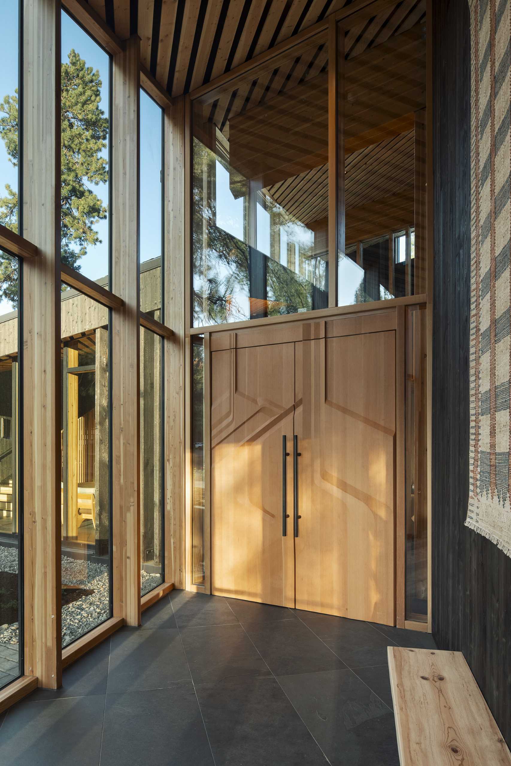 A modern ranch lodge with a black charred cedar exterior (shou sugi ban) and a warm wood interior.