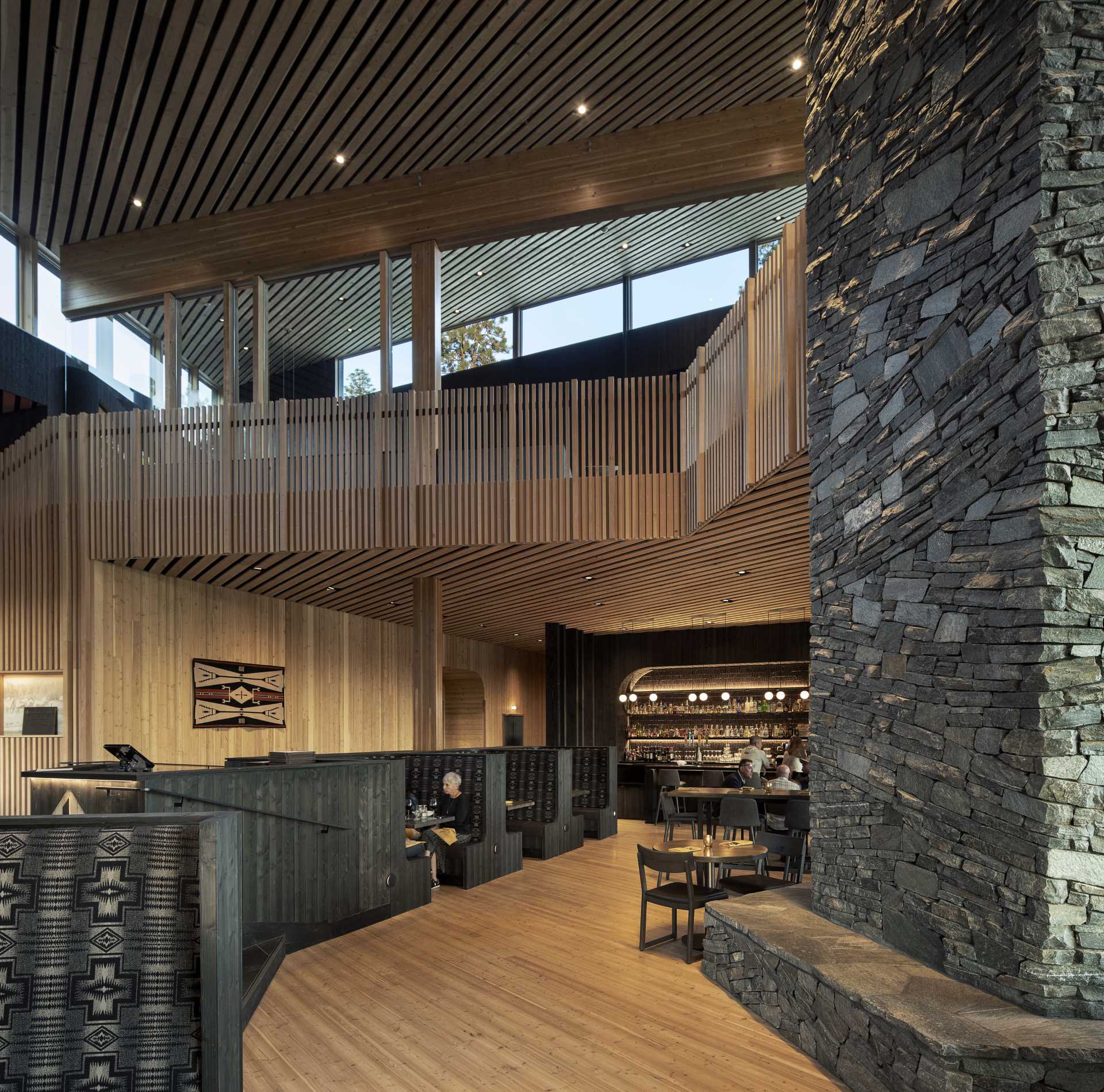 A modern ranch lodge with a black charred cedar exterior (shou sugi ban) and a warm wood interior.