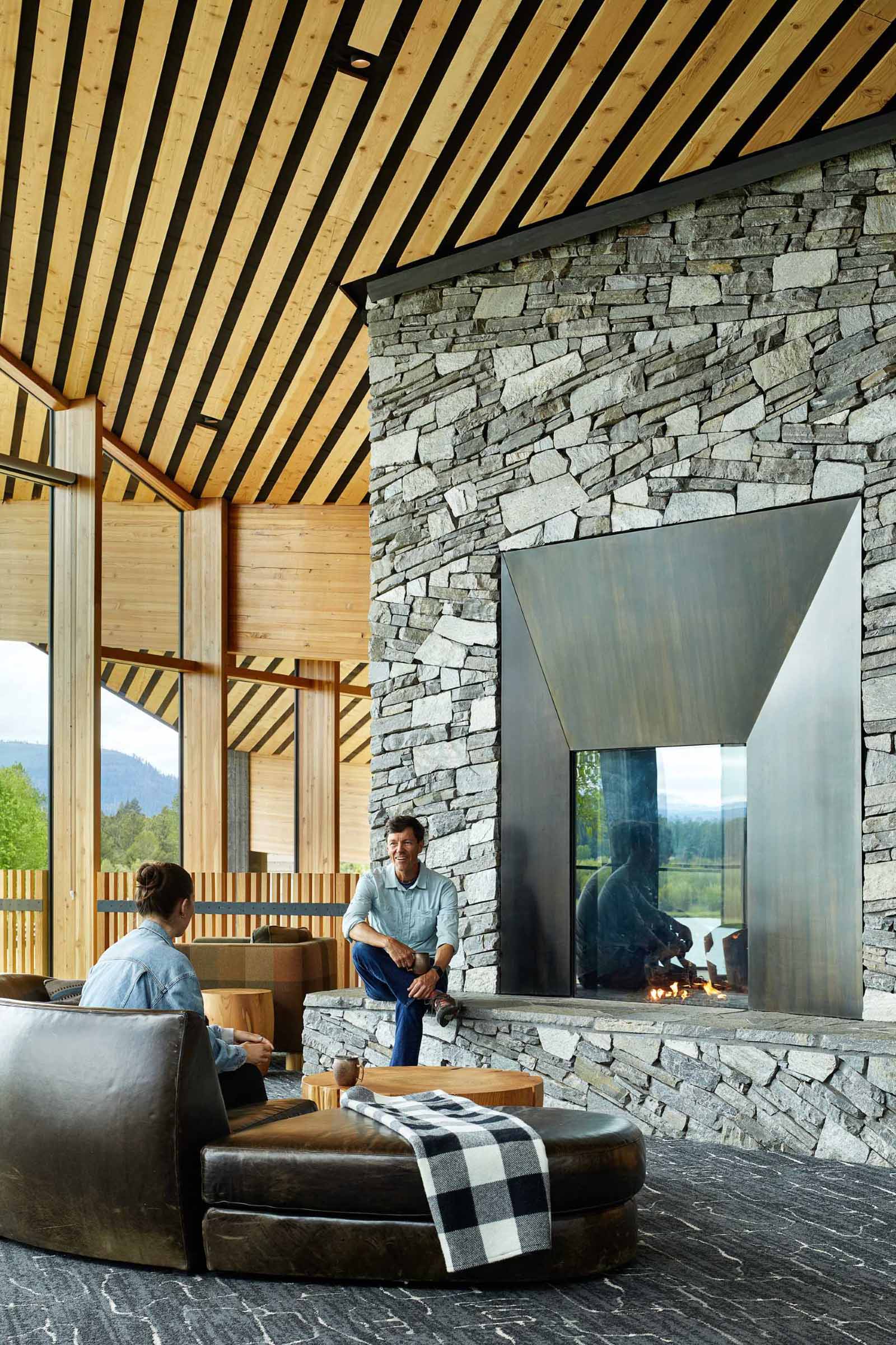 A modern ranch lodge with a black charred cedar exterior (shou sugi ban) and a warm wood interior.